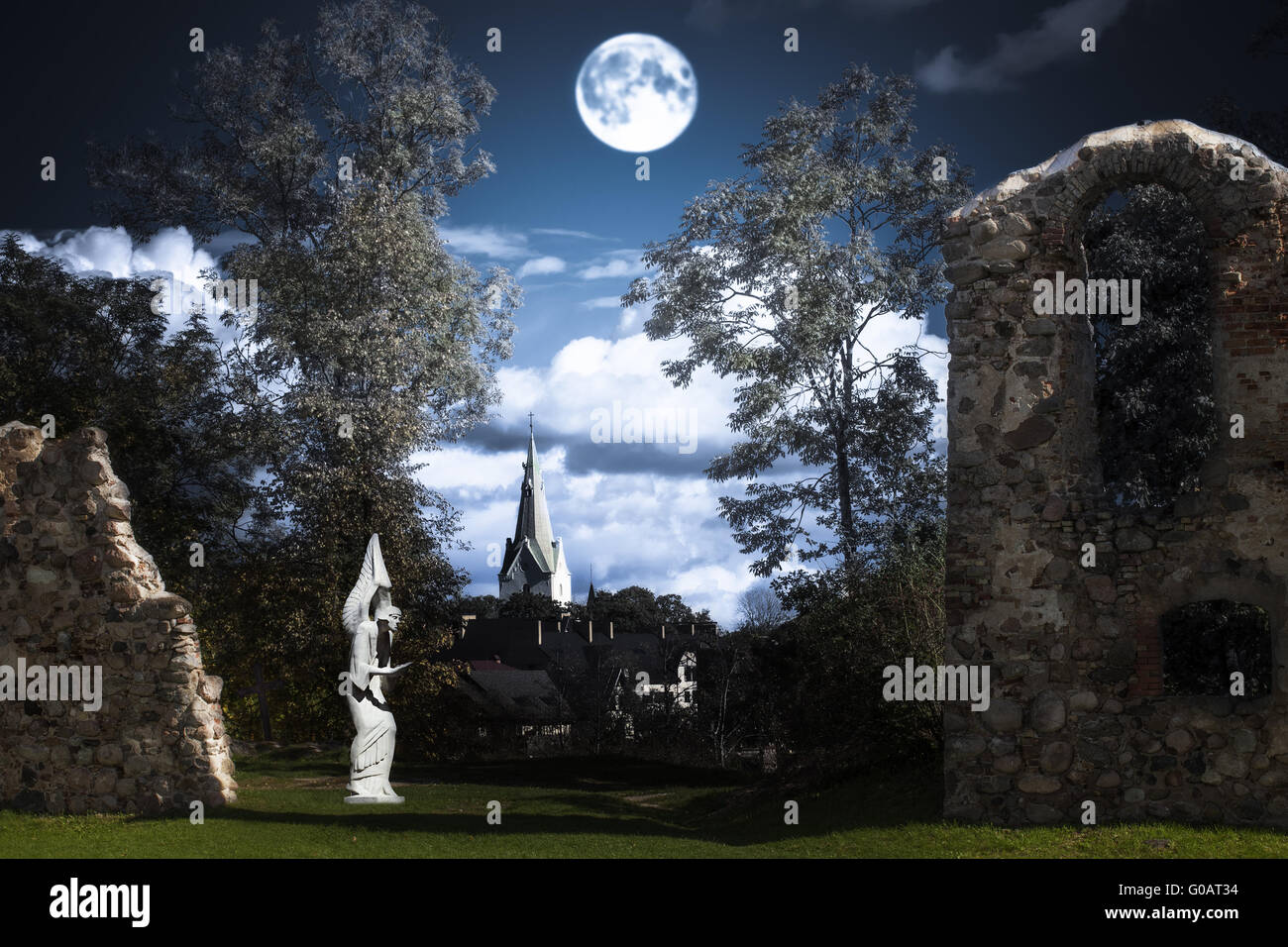 Vollmond über eine Engelsstatue und Burg-Ruinen Stockfoto