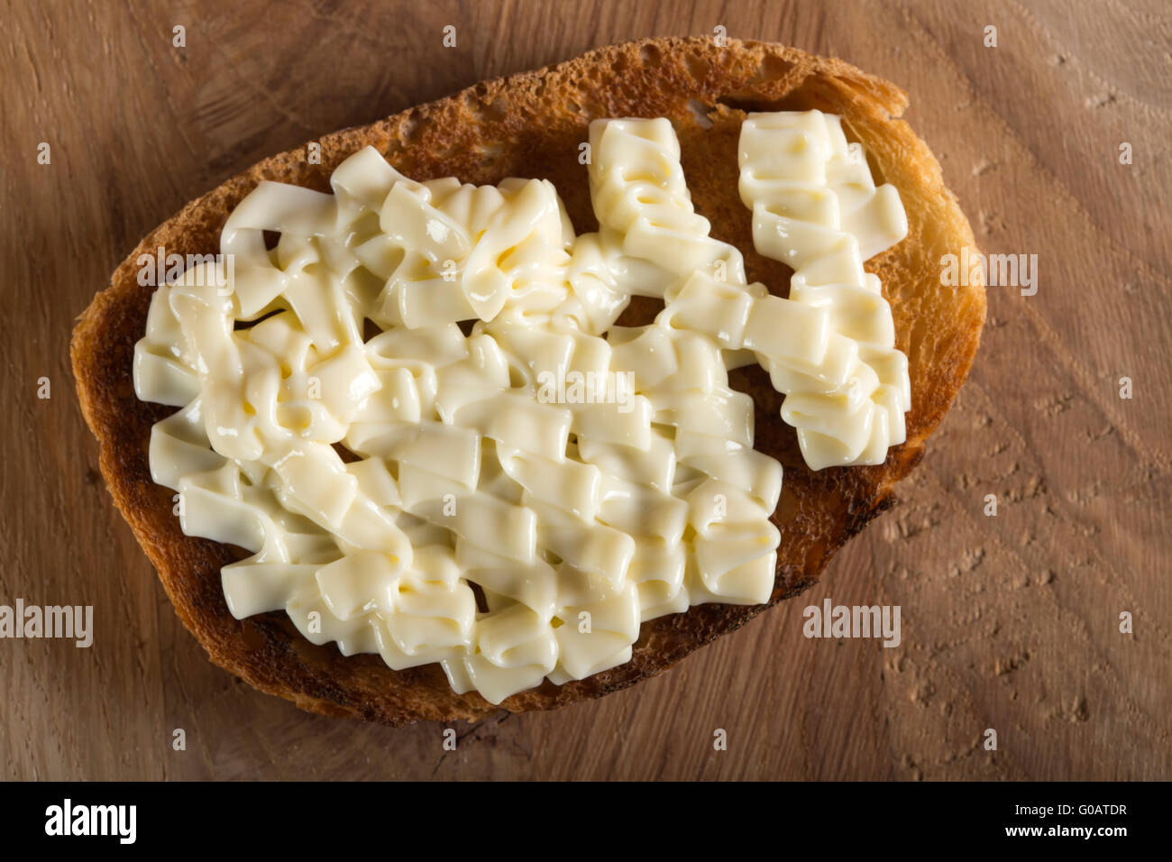 Käsecreme auf Toast über hölzerne Hintergrund geschmolzen Stockfoto