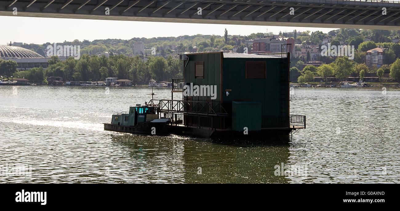 Fluss Sava, Serbien - zwei Motorboote schob ein Floßhaus gegen den Flussstrom Stockfoto