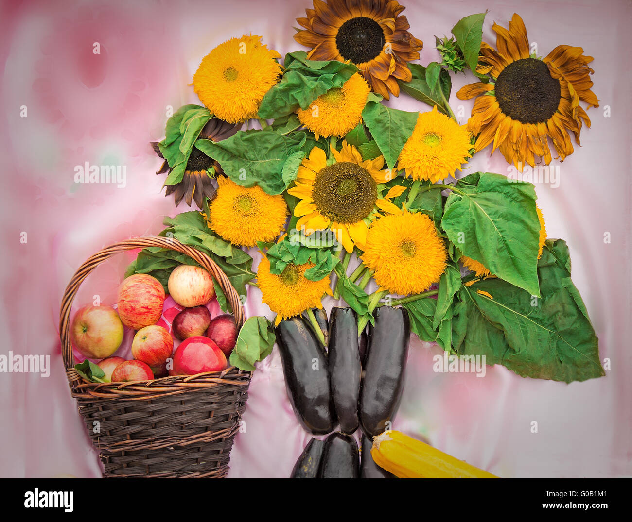 Korb mit Äpfeln und einem Bouquet aus Blumen von einem Stockfoto