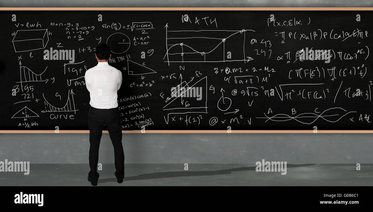 Unternehmer denken und mit Blick auf die große Tafel mit Mathe-äquivalente darauf geschrieben steht Stockfoto