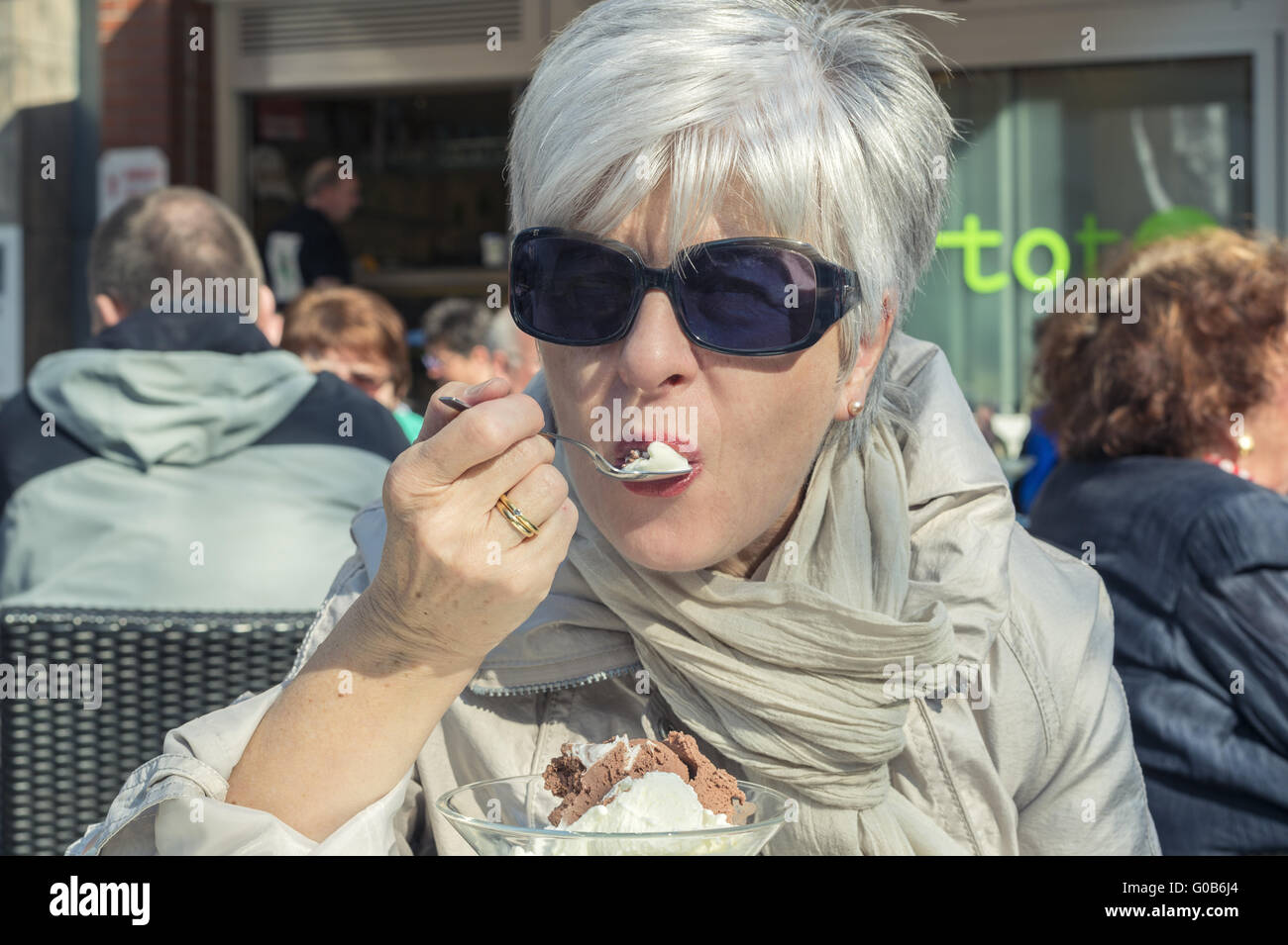 Senior mit grauen Haaren ist ein Eis Stockfoto