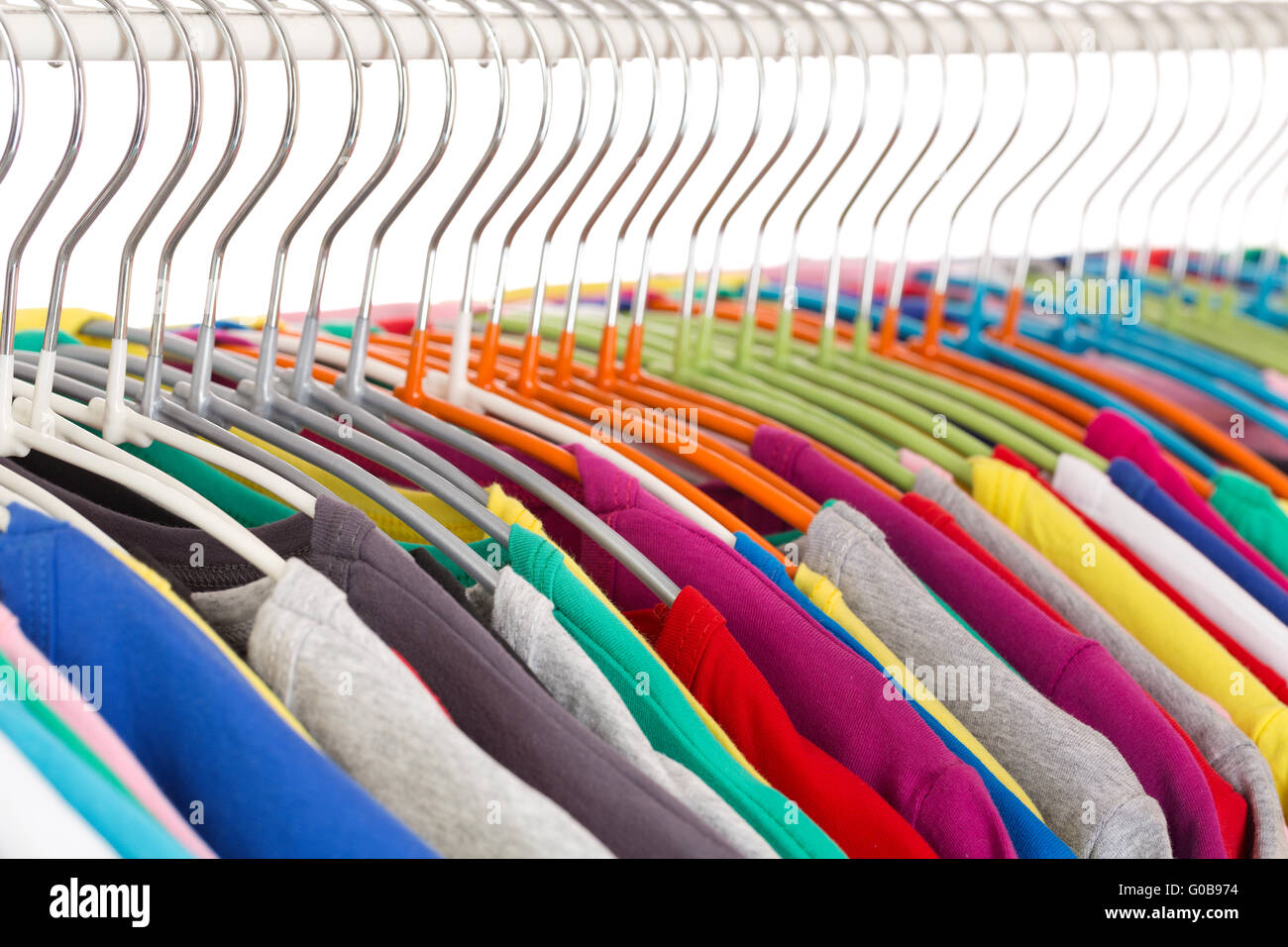 Sammlung von farbigen t-Shirts auf Stahl Kleiderbügeln Stockfoto
