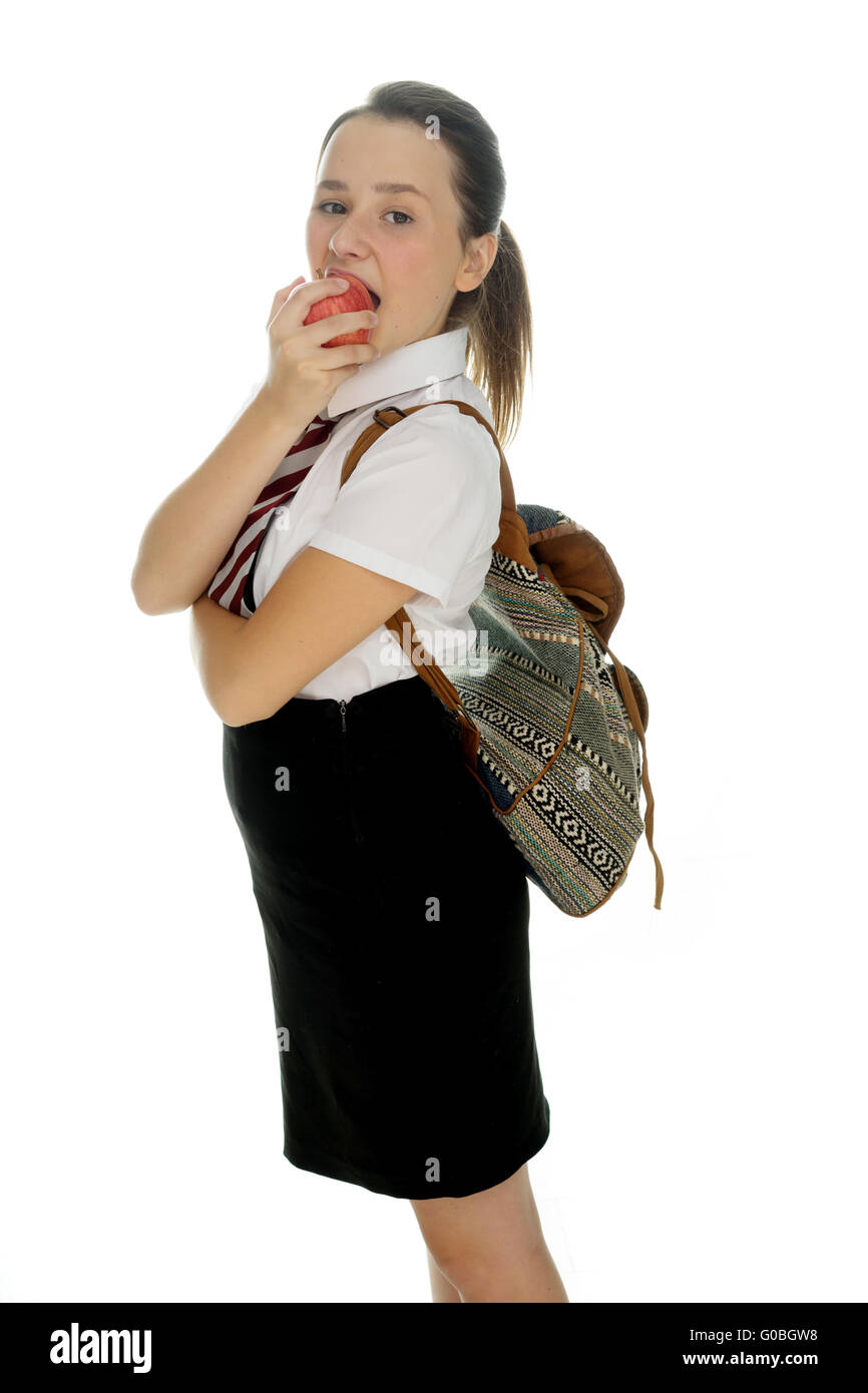 Junge Schülerin stehend einen Apfel essen Stockfoto