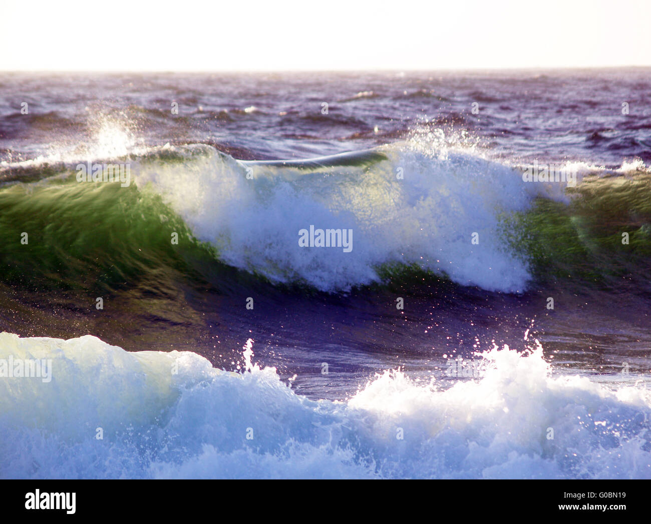 Wellen brechen ab hinterleuchtete durch Sonnenlicht Stockfoto