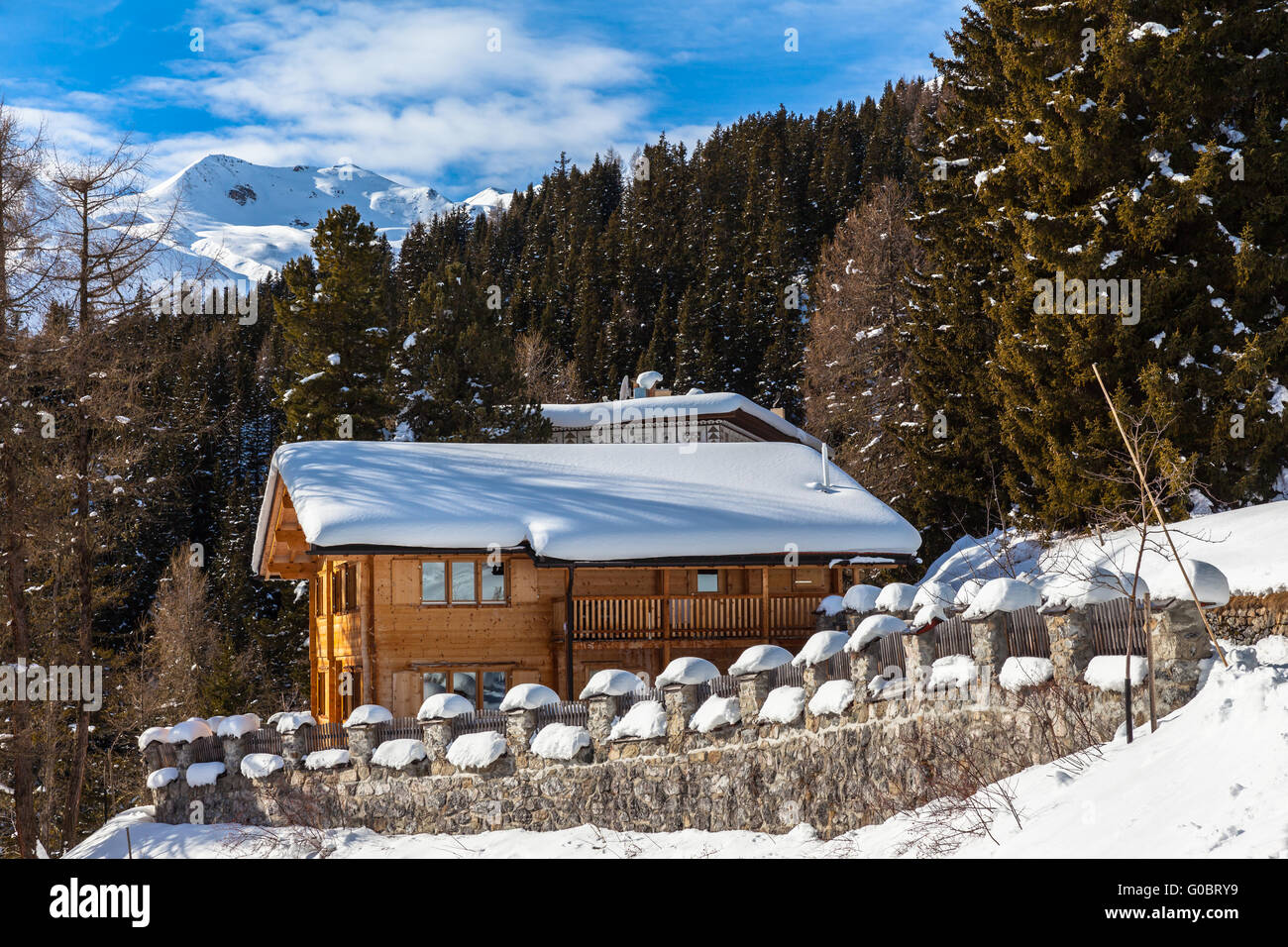 Schöne Aussicht auf Holzhaus mit Schnee bedeckten Dach im Winter, Davos, Schweiz. Stockfoto