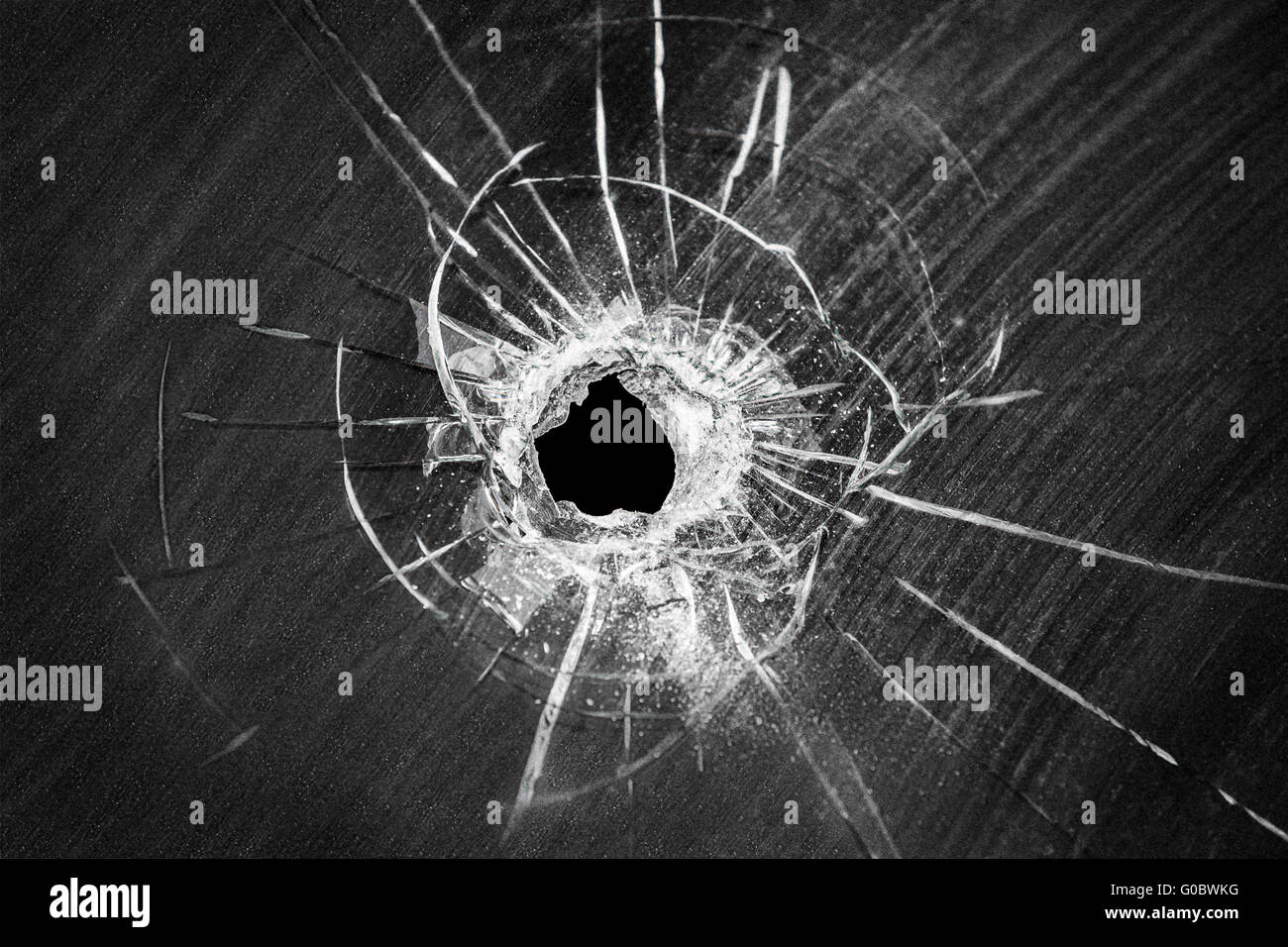 Kugel erschossen rissige Loch auf zerbrochenes Fensterglas Stockfoto