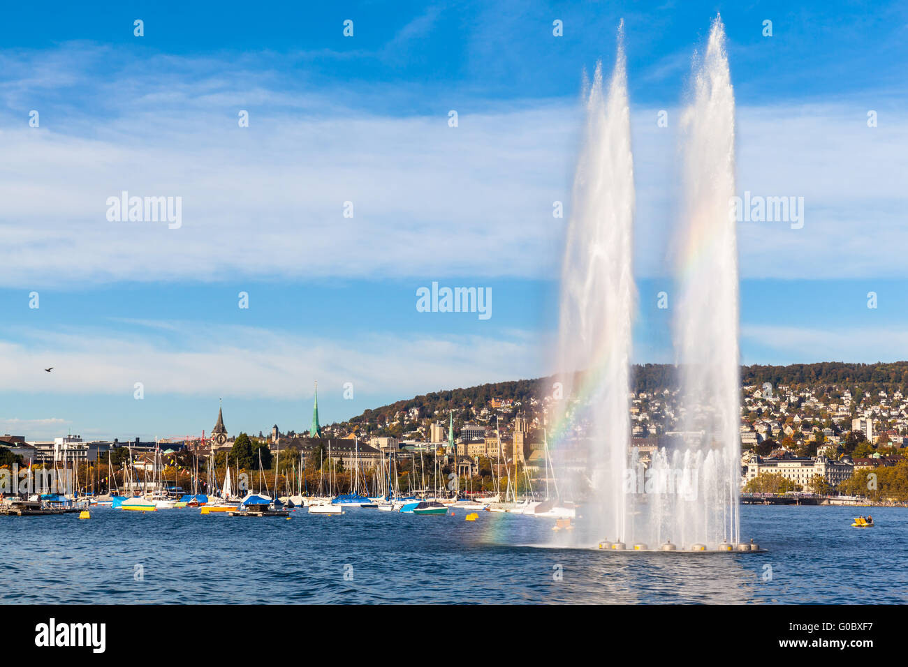 Schöner Blick auf den Brunnen am Mythenquai mit Rainbow in den Zürichsee und das Stadtbild der Altstadt Zürich bei Sonnenuntergang, Sw Stockfoto