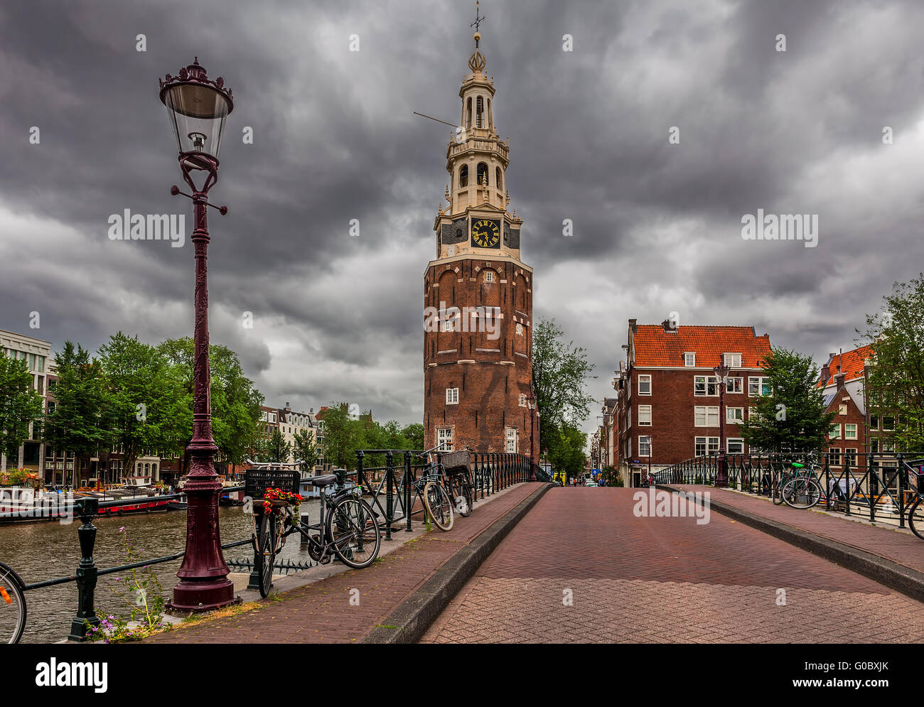 Laterne auf die Brücke und Montelbaansturm Turm unter dramatischen Wolkenhimmel in Amsterdam, Niederlande. Stockfoto