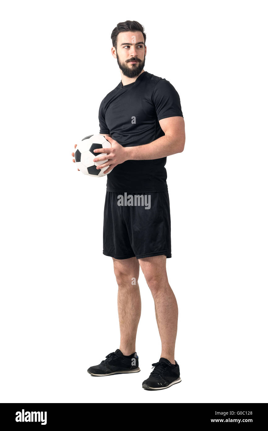 Starke zuversichtlich Fußballspieler mit Ball mit beiden Händen wegsehen. Ganzkörper-Länge-Porträt isoliert auf weißem Hintergrund Stockfoto