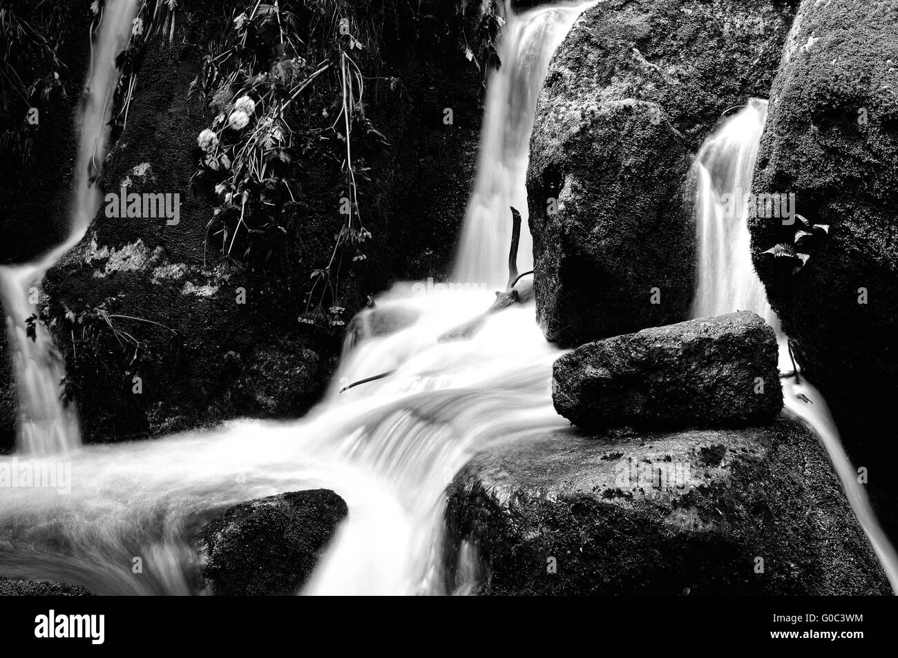 Weiches Wasser zwischen den Felsen schwarz / weiß Stockfoto