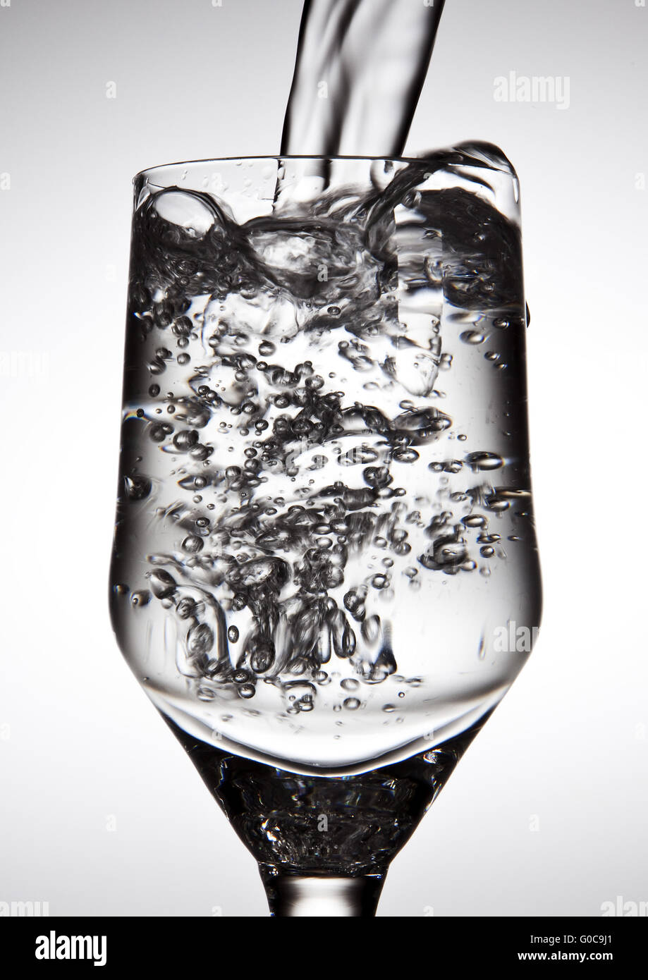 Wasser wird in ein Glas gegossen werden Stockfoto