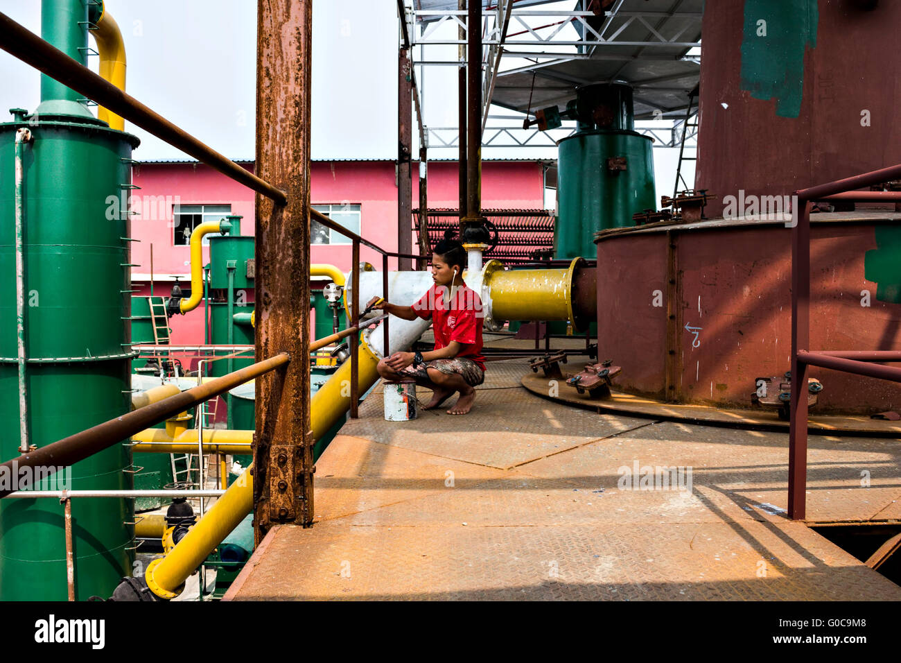 ein Maler Paiting Rost und Flecken in ein Biomasse-Kraftwerk, Hetauda, Nepal Stockfoto