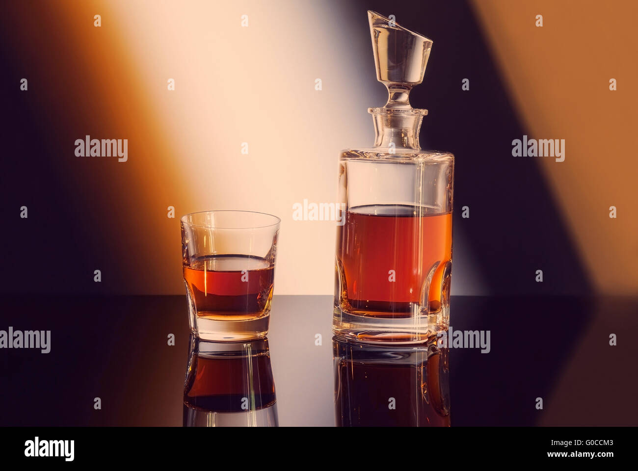 Flasche und Glas Whiskey auf Farbverlauf Hintergrund Stockfoto