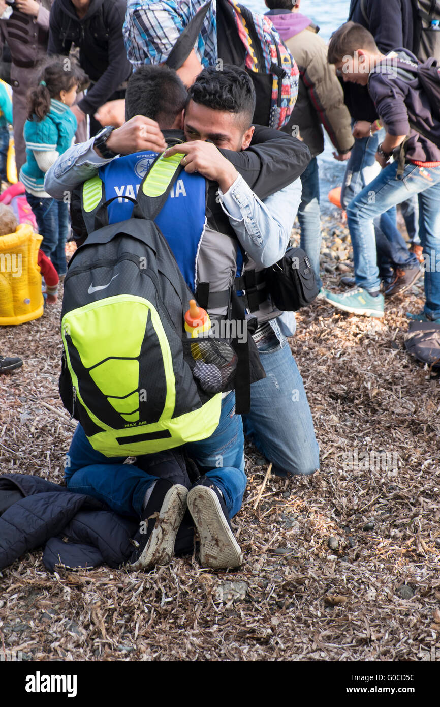 Zwei junge syrische Flüchtlinge umarmen mit Freude sich nach einer erfolgreichen Überquerung aus der Türkei auf der griechischen Insel Lesbos. Stockfoto