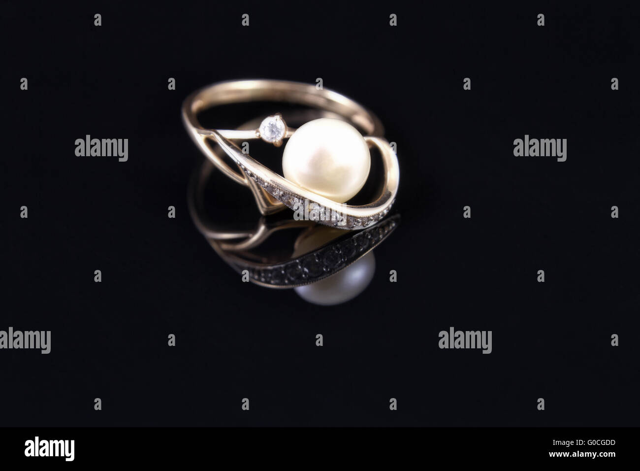 Goldring mit einer Perle wird vom Boden reflektiert. Stockfoto