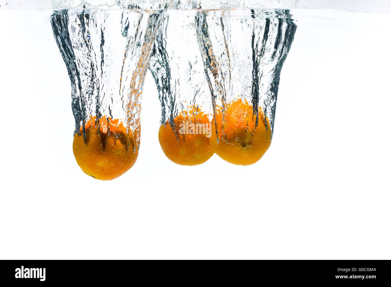3 Mandarinen Früchte fallen tief unter Wasser Stockfoto