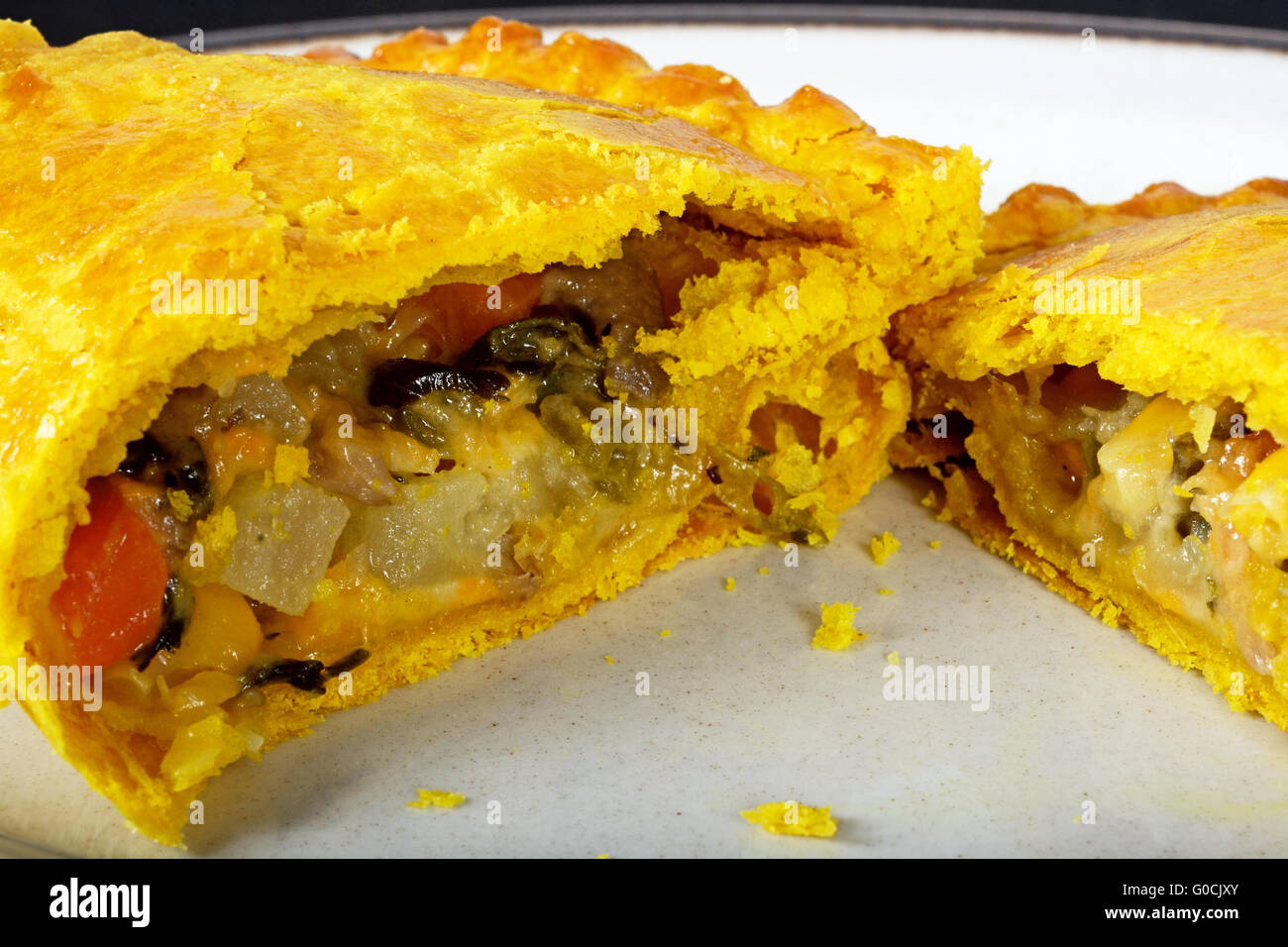 Gefüllt mit Cheddar-Käse, Zwiebel, Karotte, Schwede, Kartoffeln und Süßkartoffeln in Teig halbieren vegetarische pastös. Stockfoto