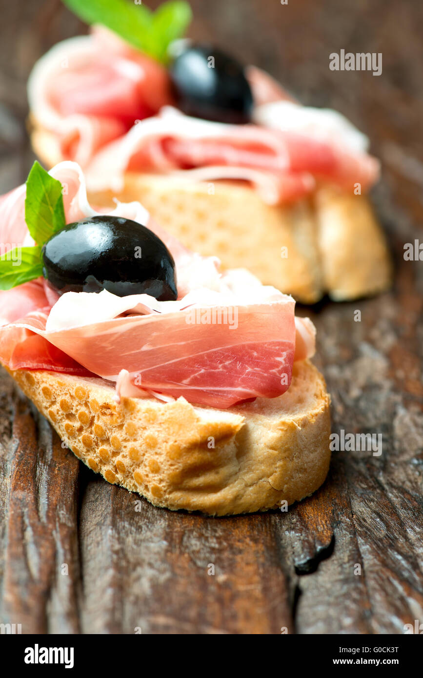 Sandwiches mit Schinken-Oliven auf alten Holztisch vertikale Stockfoto