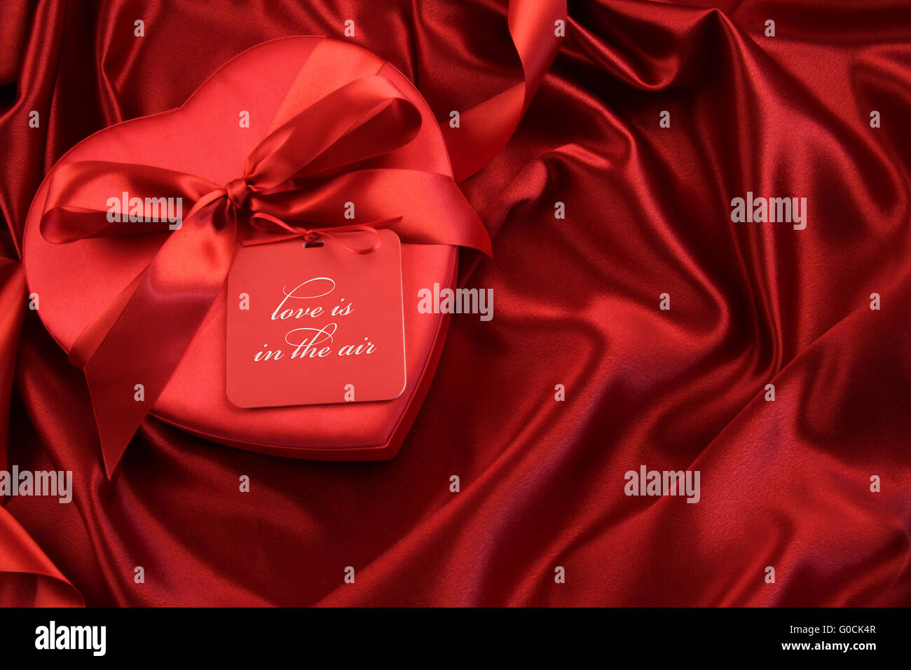 Pralinenschachtel mit Geschenkkarte auf satin Hintergrund Stockfoto