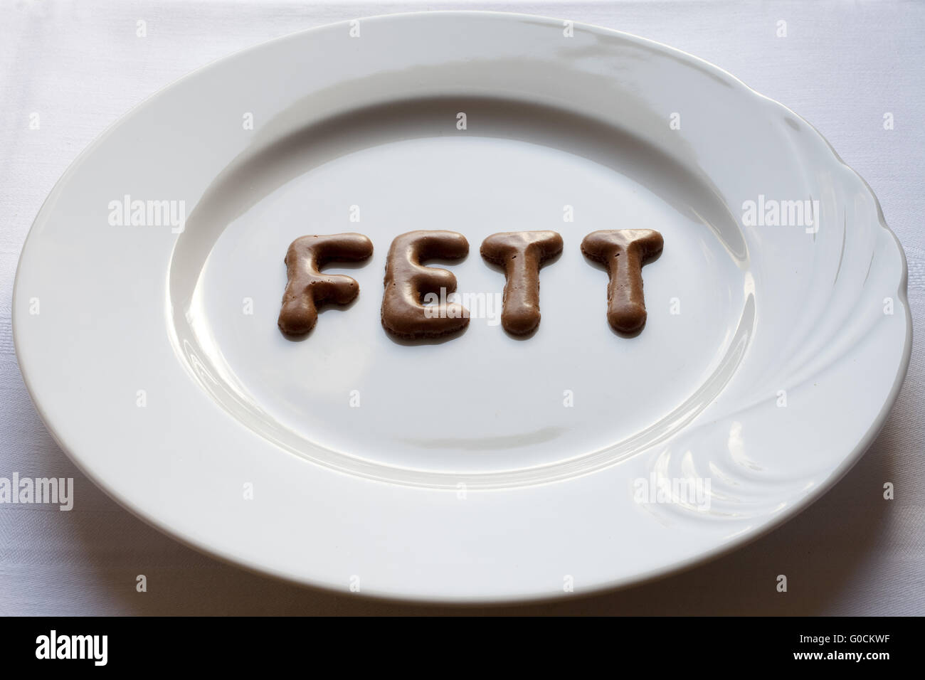 Buchstaben, das Wort Fett auf einem Teller Stockfoto