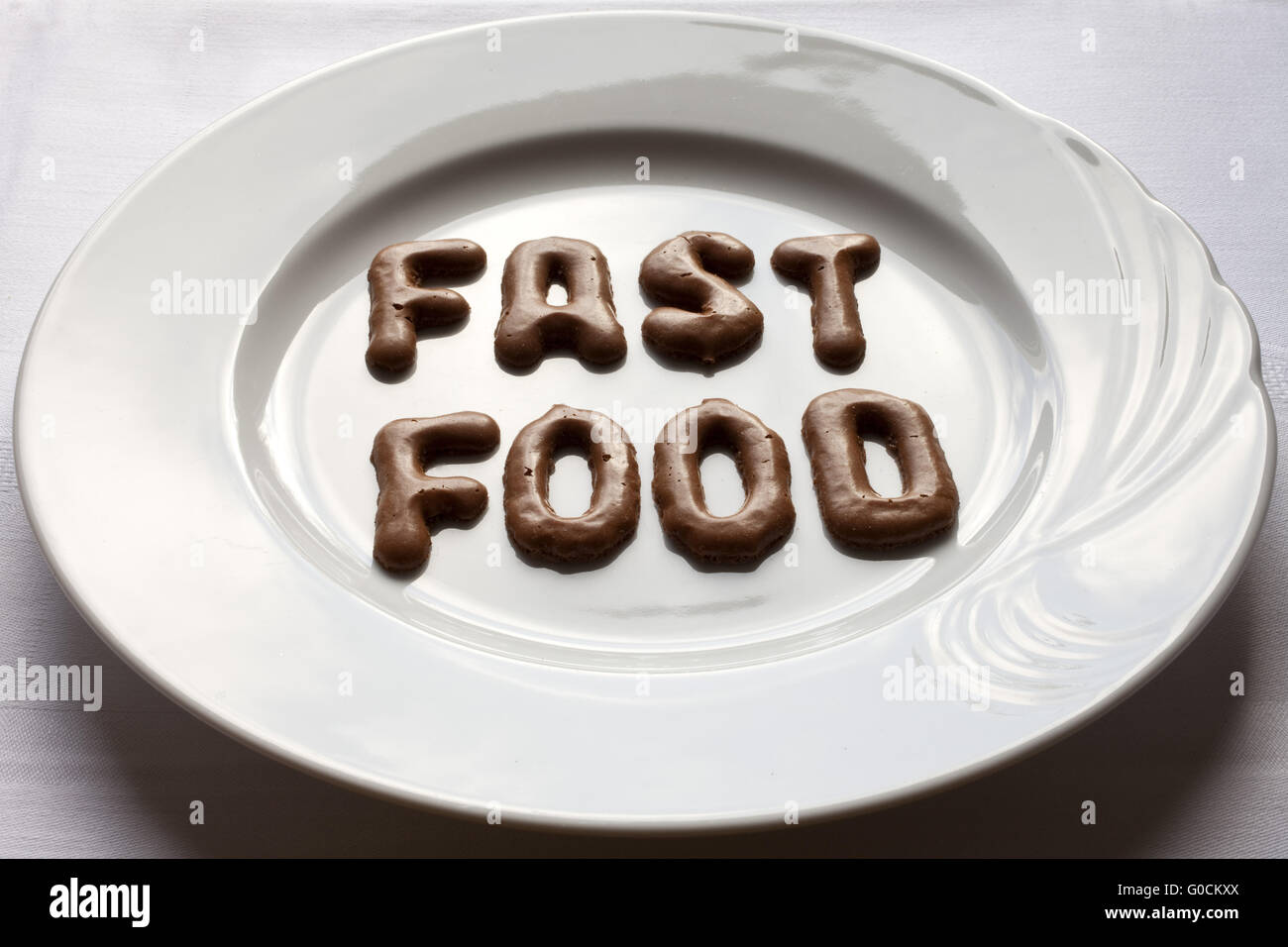 Buchstaben, das Wort fast-Food auf einem Teller Stockfoto