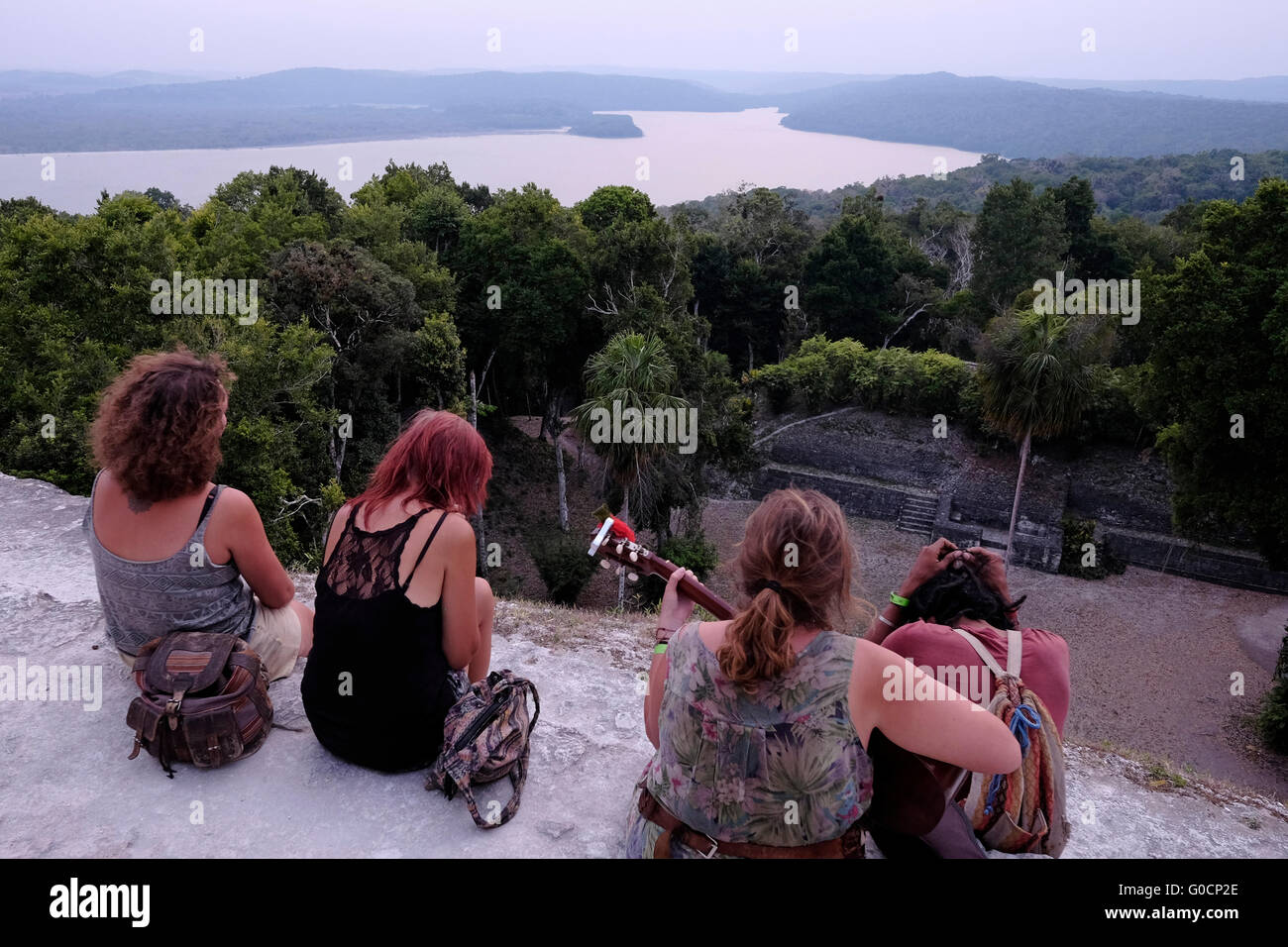 Touristen Blick auf Lake Petén Itzá aus einem alten Maya Ruine in Yaxha eine mittelamerikanische Ausgrabungsstätte im Nordosten der Region Peten-Becken und ein ehemaliger zeremonielles Zentrum und eine Stadt der präkolumbischen Maya-Zivilisation befindet sich in der heutigen Abteilung des Petén, nördlichen Guatemala Stockfoto