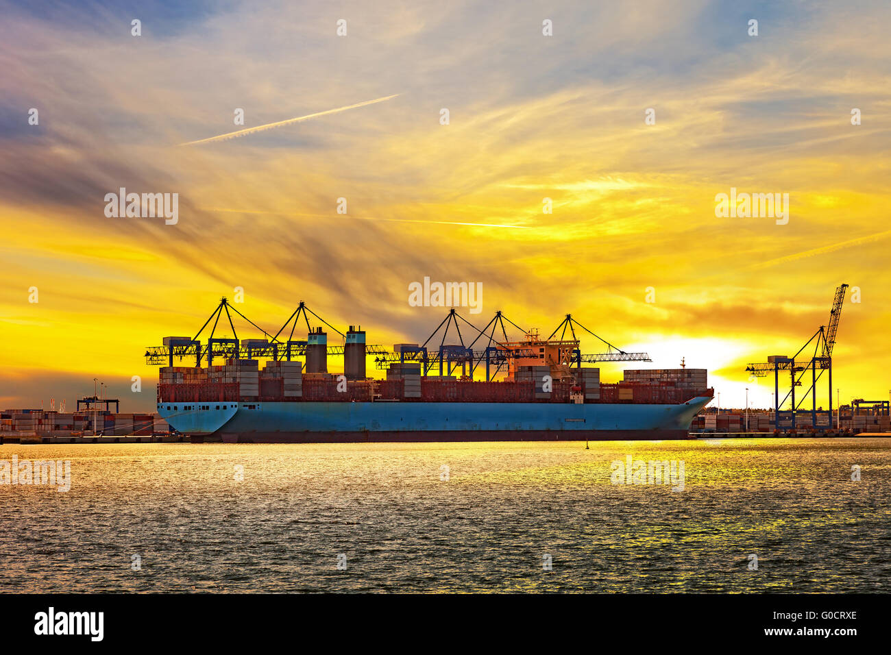 Containerschiff bei Sonnenuntergang im Hafen von Danzig, Polen. Stockfoto