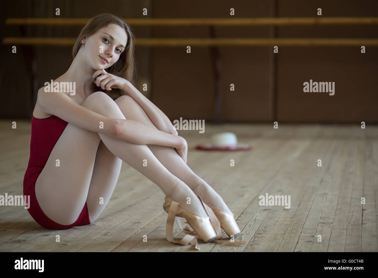 Porträt einer jungen Ballerina auf dem Boden sitzend Stockfoto