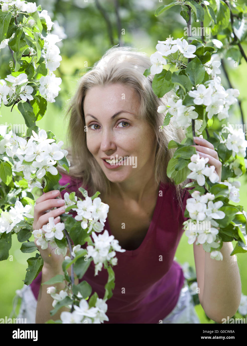 Frau stand in der Nähe des blühenden Apfelbaums. Stockfoto