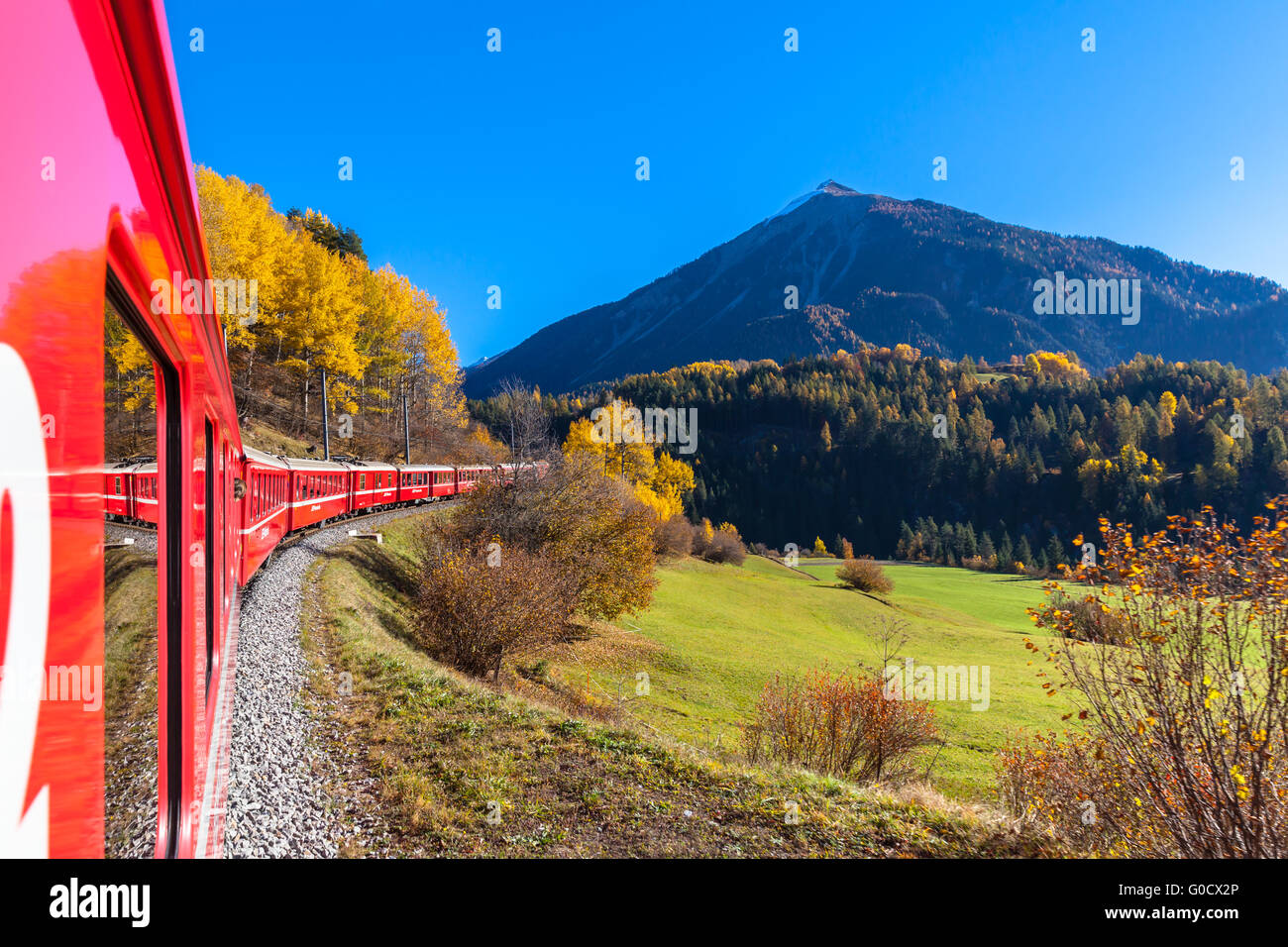 Reisen Sie mit dem Zug der Rhätischen Bahn im goldenen Herbst durch die Linie der Glacier Express im Engadin, Kanton Graubünden, Ausrüstu Stockfoto