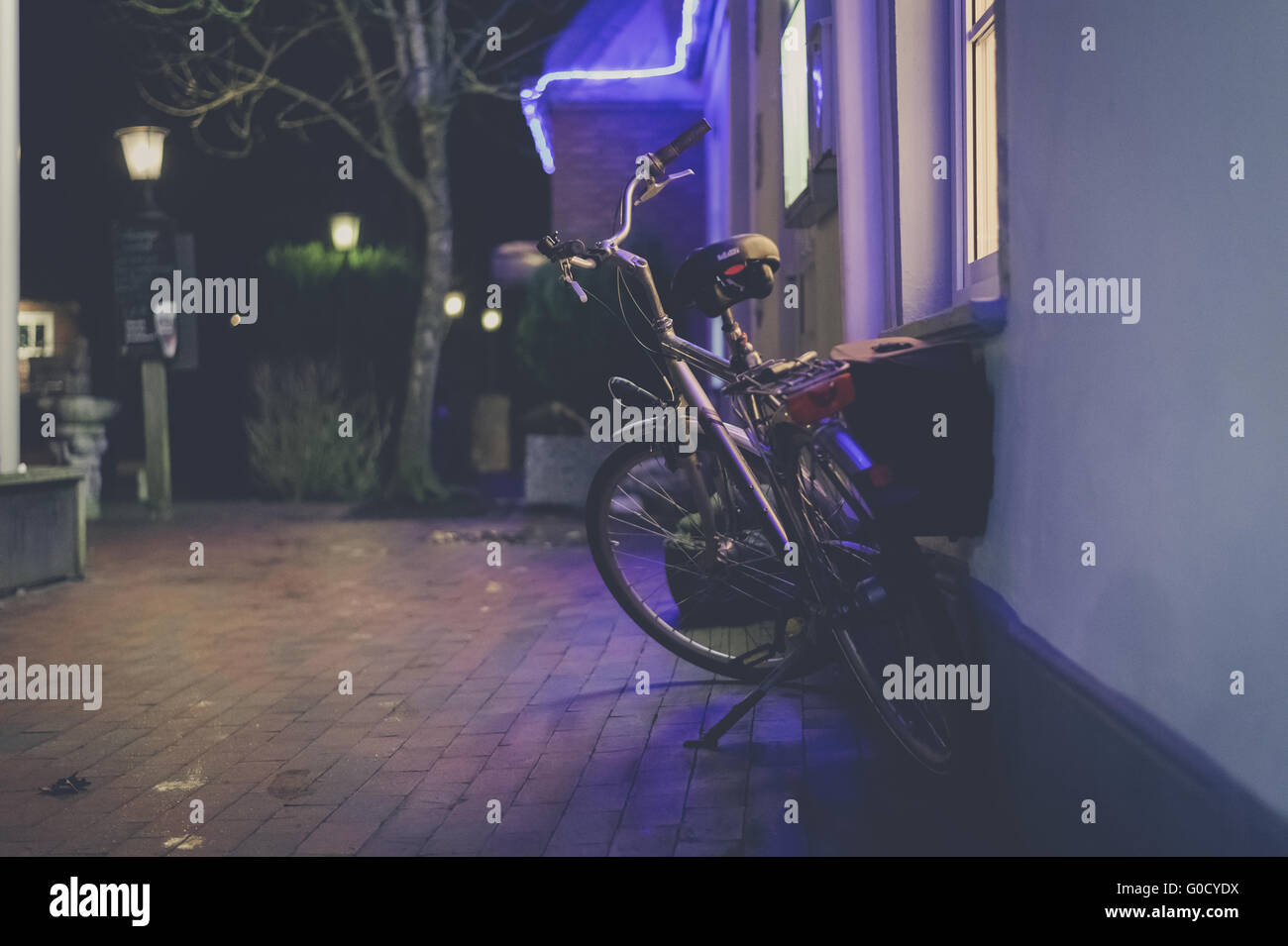 Ein Fahrrad ist in der Nacht vor einem pub Stockfoto