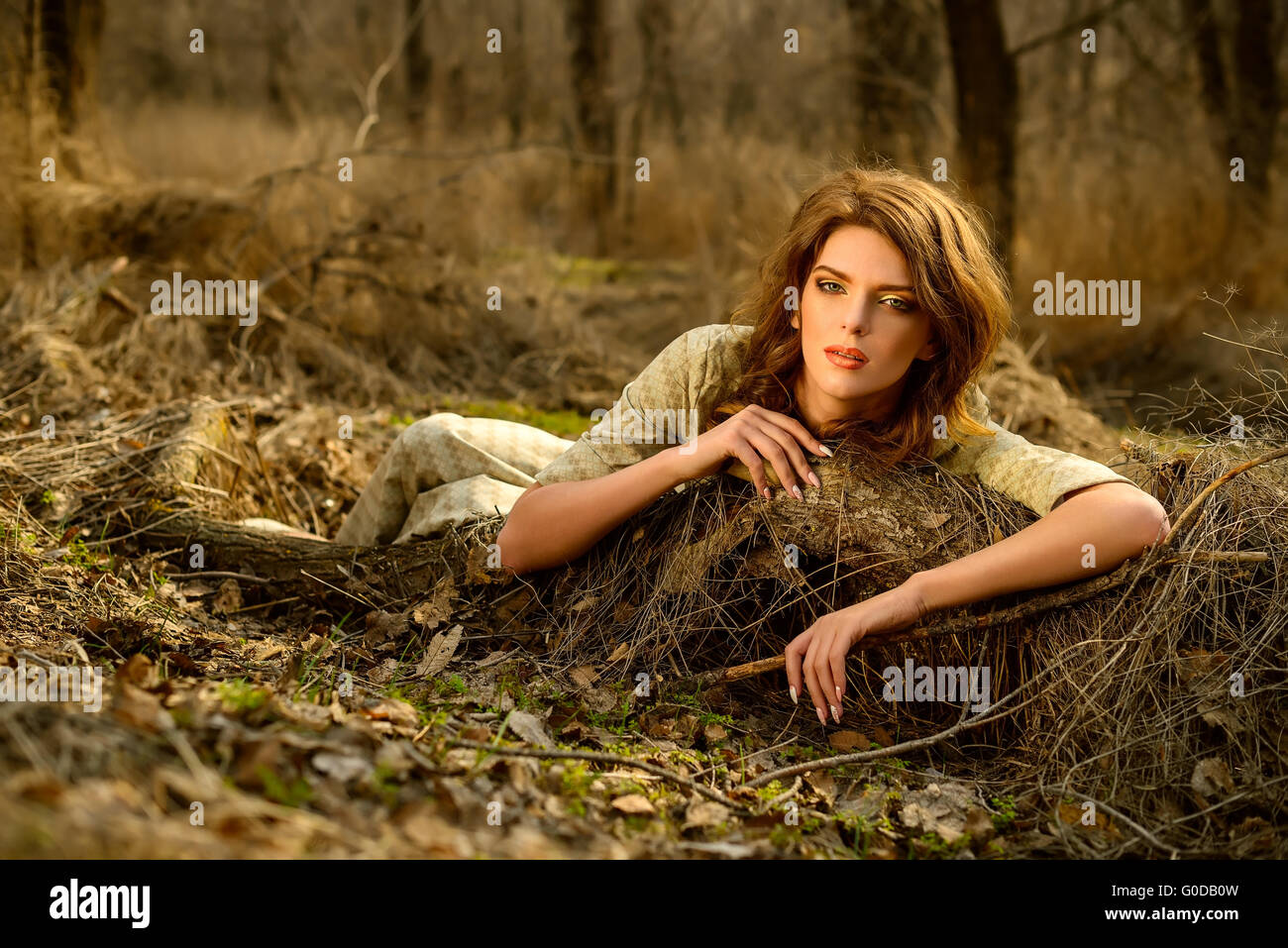 schönes Mädchen liegt auf einem Baumstamm in das Frühholz Stockfoto