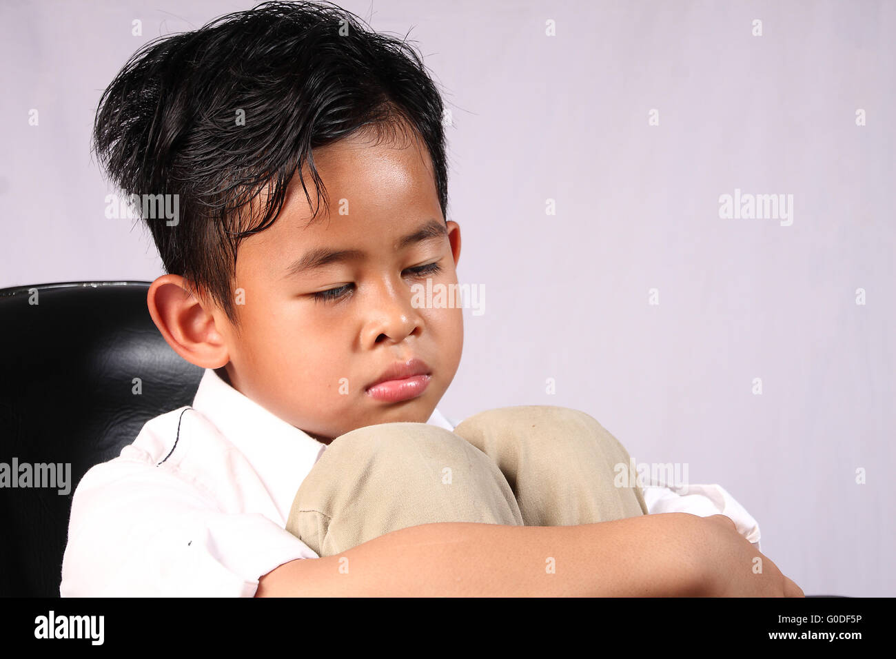 Porträt von traurig Asian Boy legte sein Gesicht auf die Knie Stockfoto