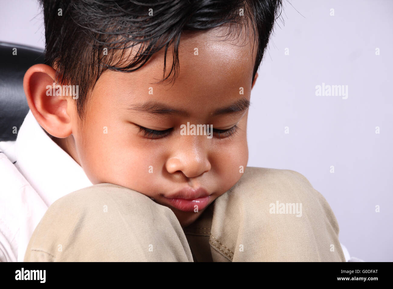 Porträt von traurig Asian Boy legte sein Gesicht auf die Knie Stockfoto