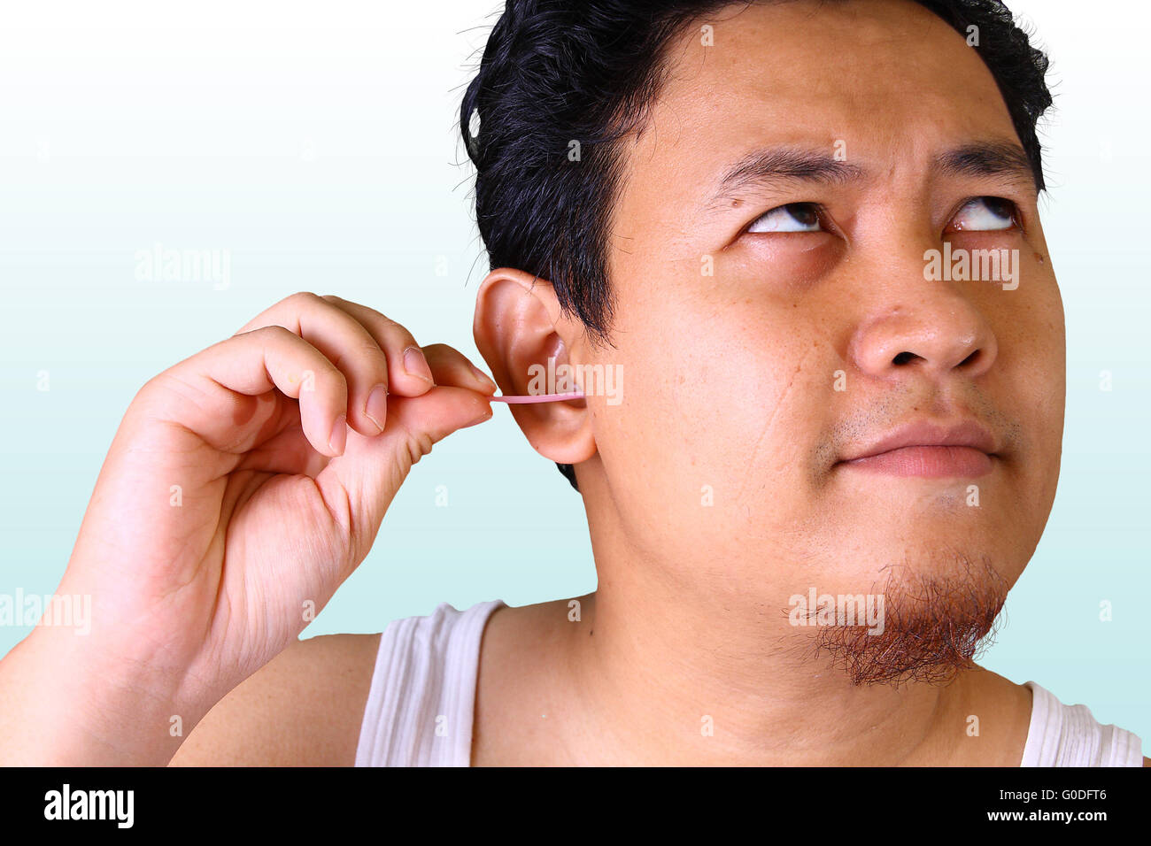 Junge asiatische Mann sein Ohr mit Wattestäbchen reinigen Stockfoto