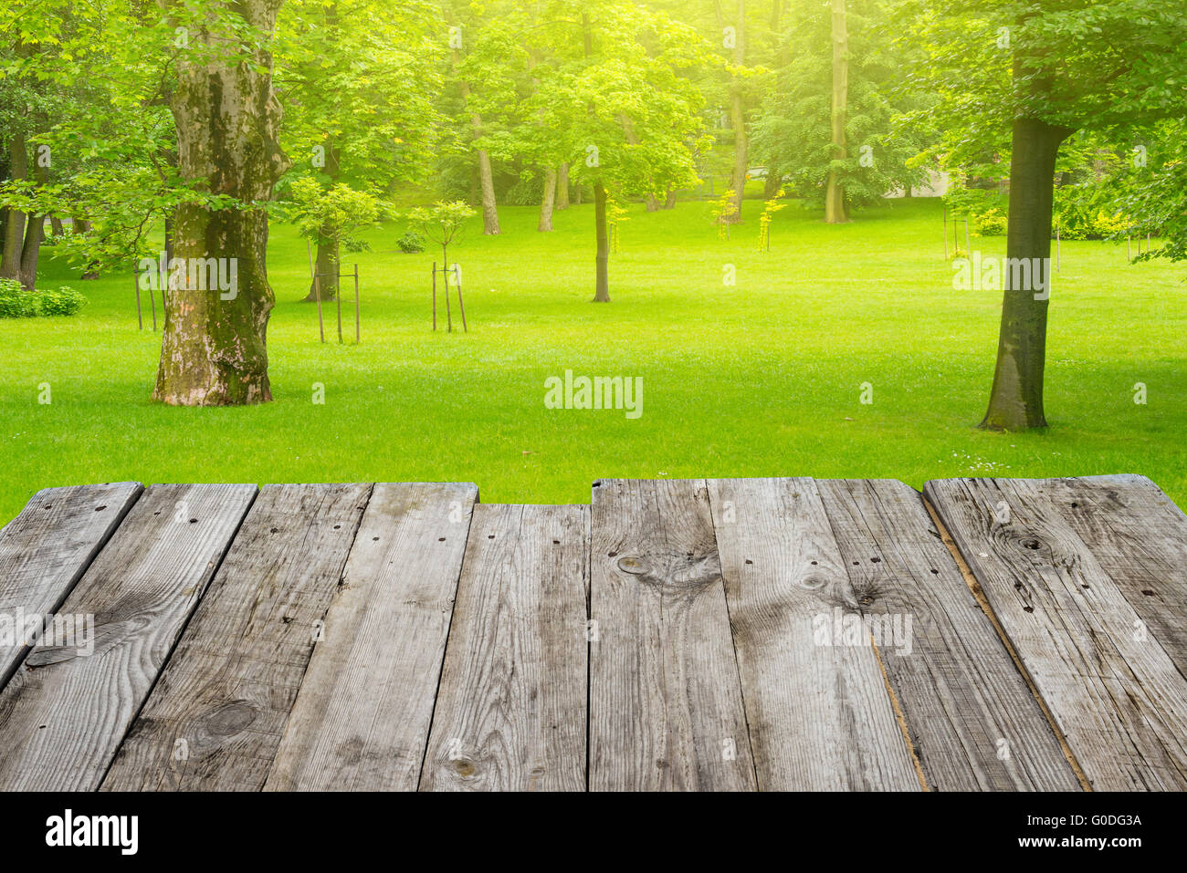 Blick vom Holztisch in den grünen Bokeh-Hintergrund Stockfoto