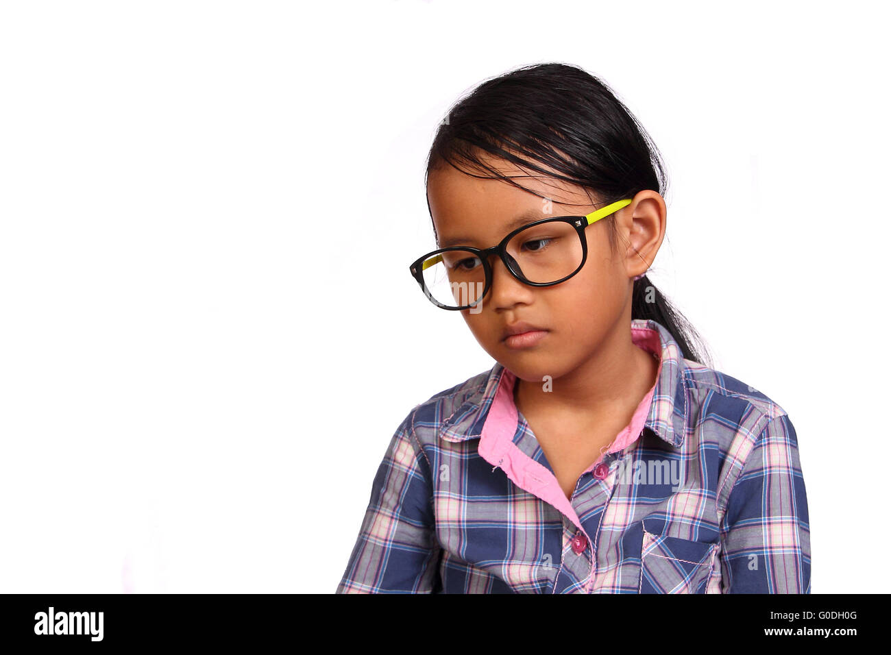 Kleines Mädchen mit Brille mit leeren Blick isoliert auf weiss Stockfoto