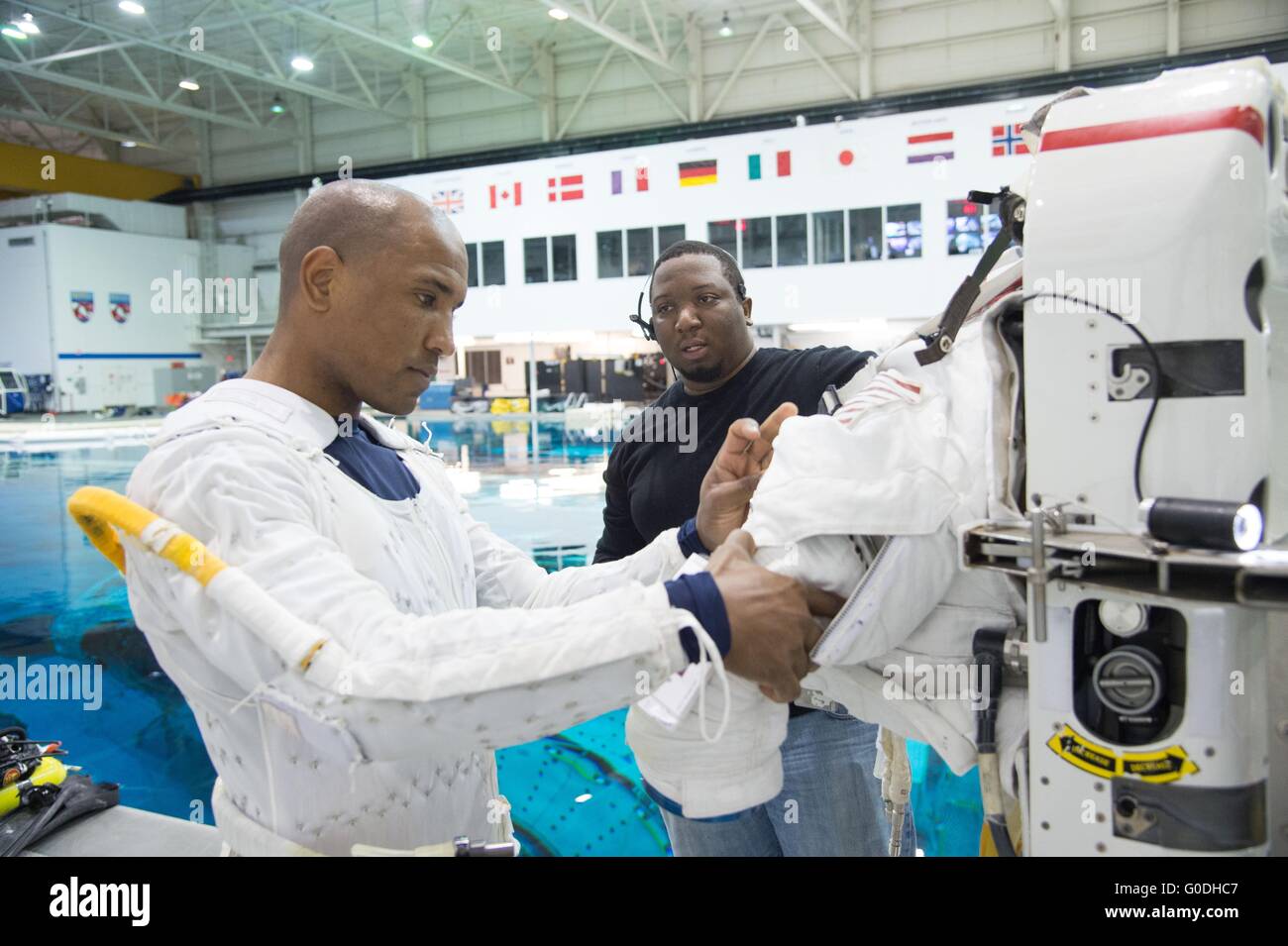 NASA-Astronaut Victor Glover baut seinen Raumanzug Extravehicular Mobility Unit vor dem Abstieg in den Pool während ISS EVA Ausbildung an der neutralen Auftrieb Labor Johnson Space Center 27. Oktober 2014 in Houston, Texas. Stockfoto