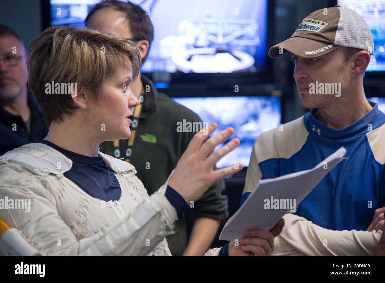 NASA-Astronaut Anne McClain plaudert mit anderen Astronauten Josh Cassada während passend bis in ihr Extravehicular Mobility Unit Raumanzug während ISS EVA Ausbildung am neutralen Auftrieb Labor Johnson Space Center 12. Januar 2015 in Houston, Texas. Stockfoto