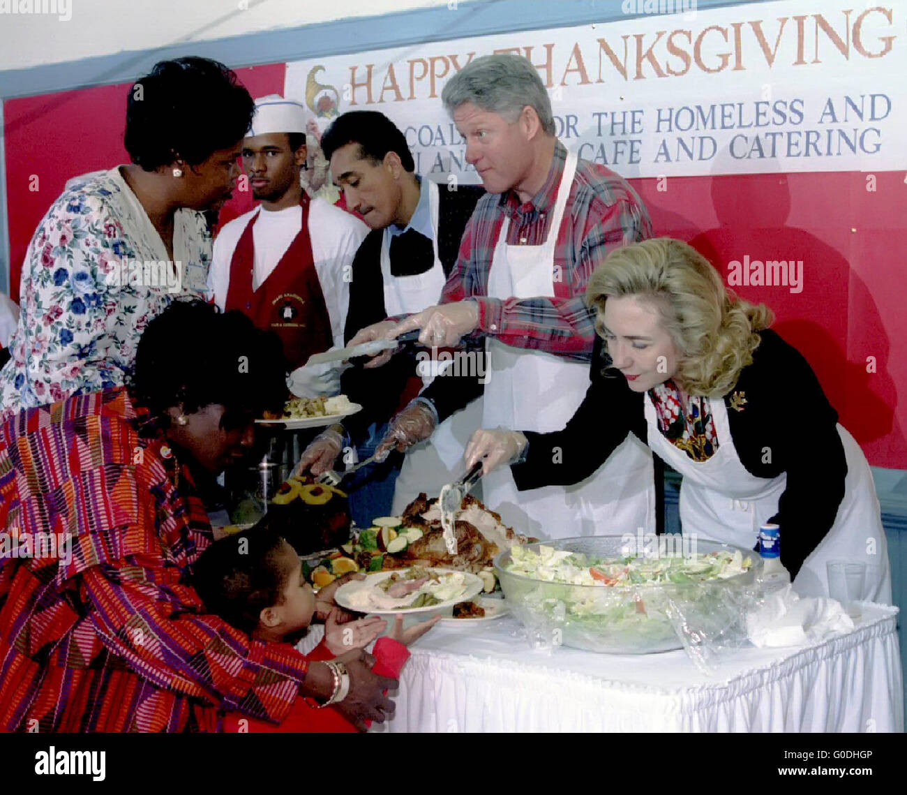 Präsident Bill Clinton und Frau Hillary Clinton mit Essen an Obdachlose bei der 1997 Thanksgiving Feier nehmen Platz in einem Obdachlosenheim Qashington D.C.. Stockfoto