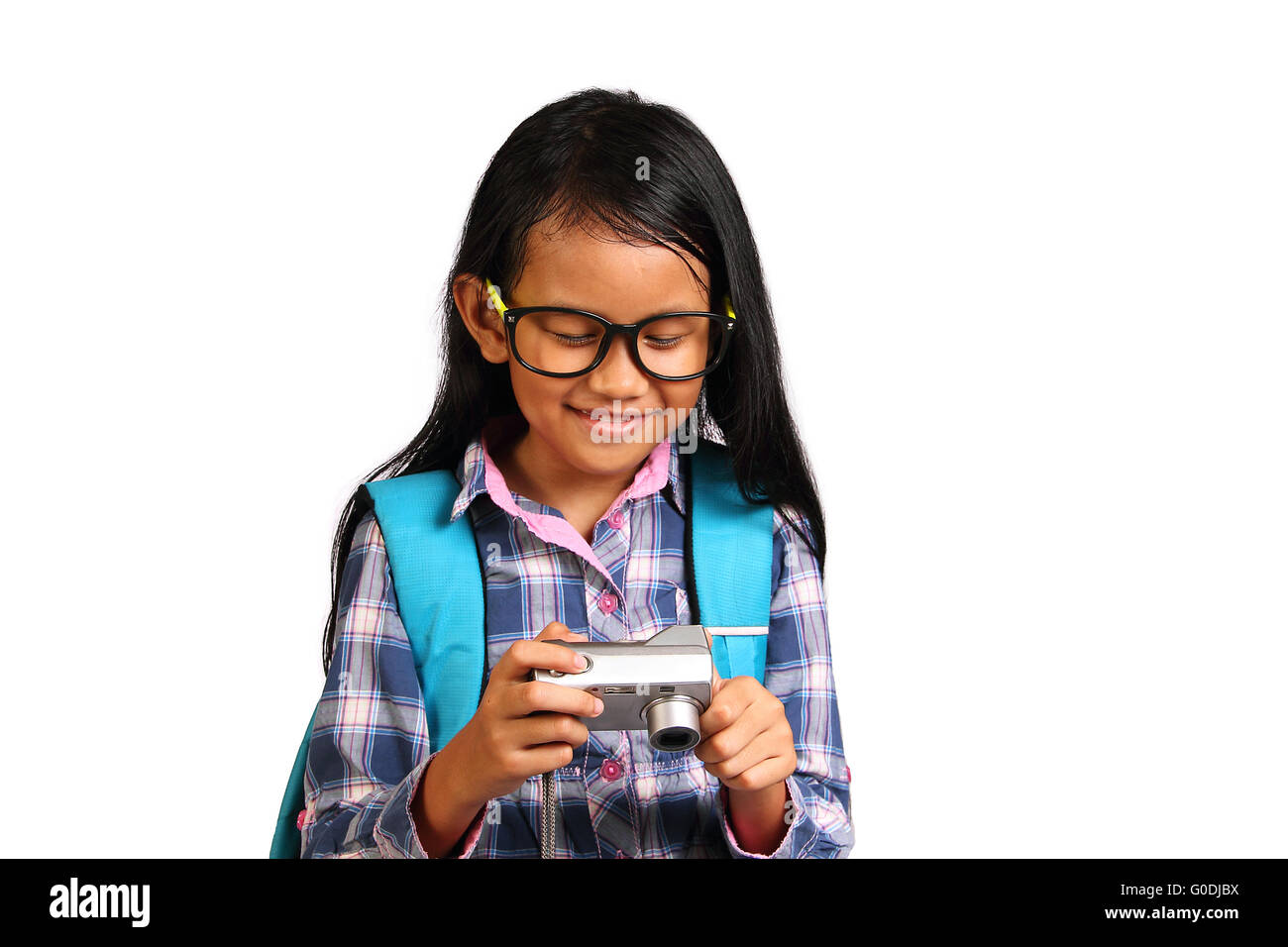 Kleines Mädchen lächelnd während der Überprüfung Bilder in ihrer Kamera isoliert auf weiss Stockfoto