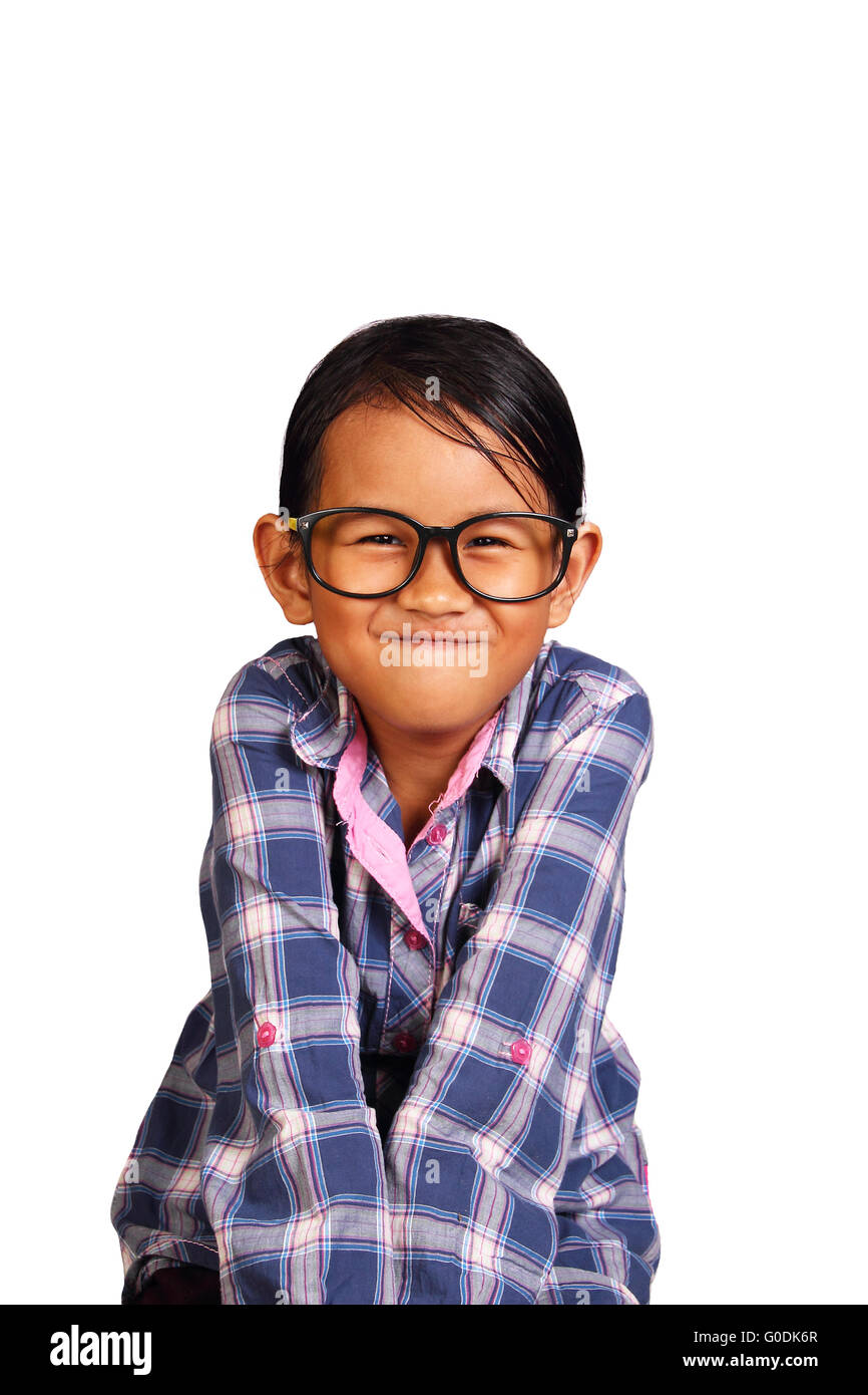 Niedliche kleine Mädchen mit Brille Durchführung eng Lippen Lächeln beim Schließen ihre Schultern isoliert auf weiss Stockfoto