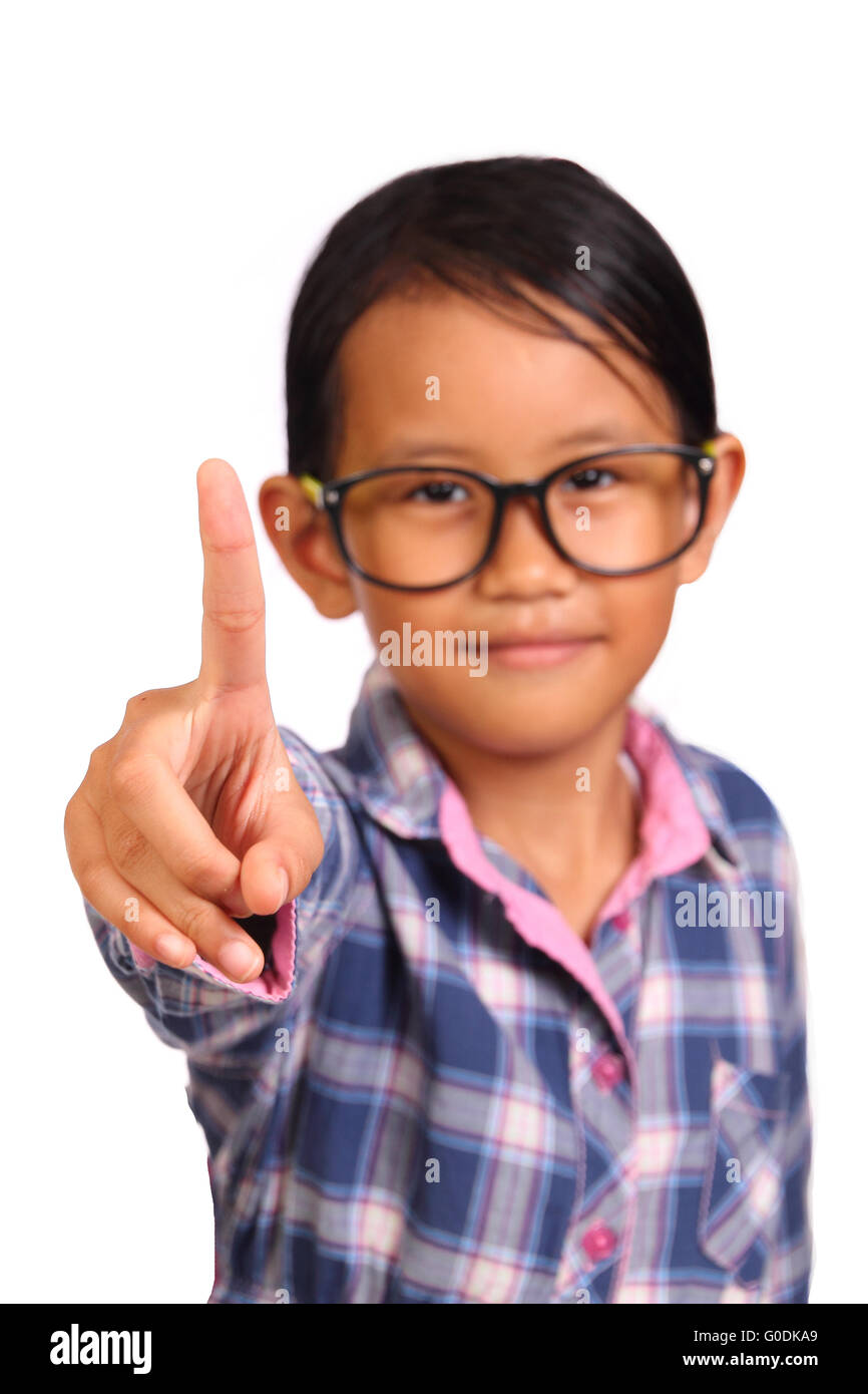 Niedliche kleine Mädchen mit Brille zeigt Nummer eins Geste mit dem Finger vor ihr isoliert auf weiss Stockfoto