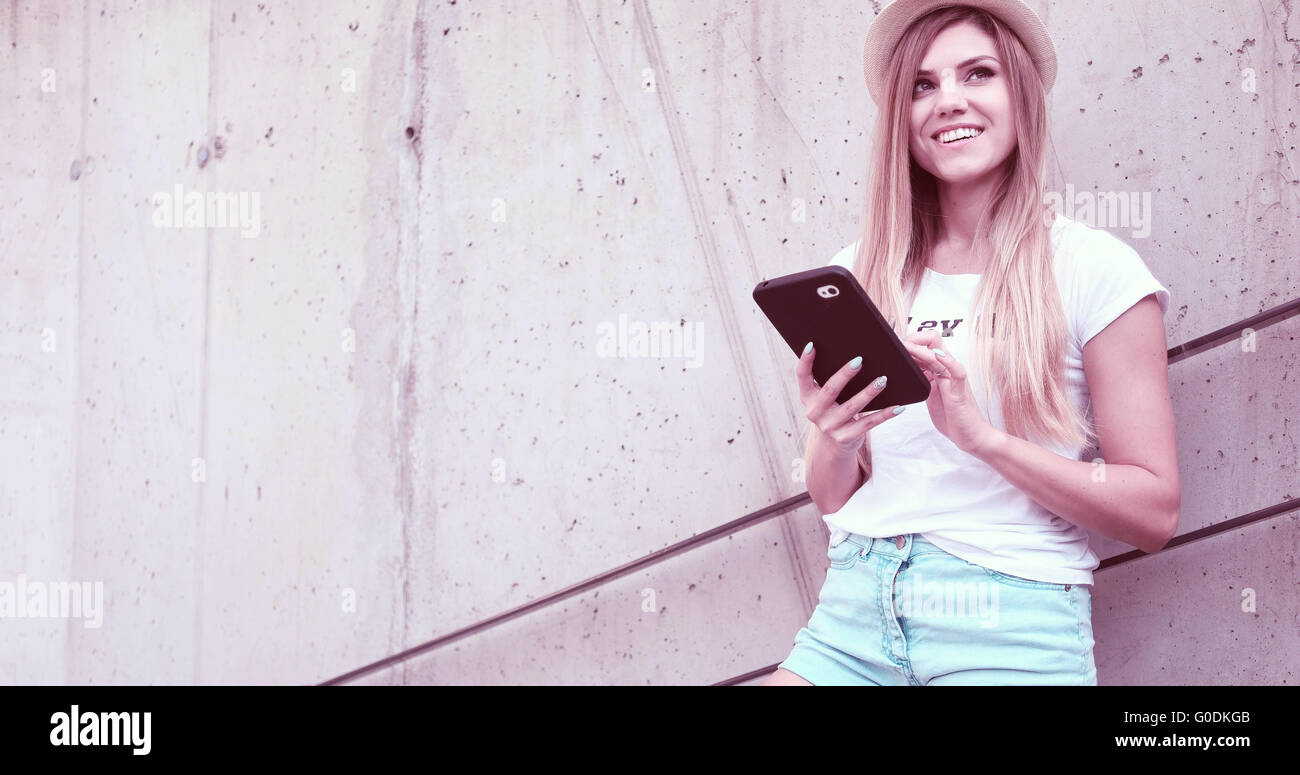 Städtischen Teengirl mit einem Tablet auf der Straße sitzen Stockfoto