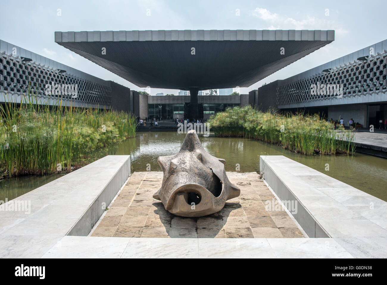 Nationalmuseum für Anthropologie Regenschirmstruktur Mexiko-Stadt Mexiko // MEXIKO-STADT, Mexiko — die berühmte Betonschirmkonstruktion dominiert den zentralen Innenhof des Nationalmuseums für Anthropologie, entworfen vom Architekten Pedro Ramírez Vázquez und fertiggestellt 1964. Das dramatische architektonische Merkmal, das von einer einzigen Säule unterstützt wird, dient sowohl als skulpturaler Mittelpunkt als auch als praktischer Unterschlupf für den zentralen platz des Museums. Das innovative Design ist ein Beispiel für die mexikanische modernistische Architektur der Mitte des Jahrhunderts und bildet gleichzeitig ein beeindruckendes Herzstück für Mexikos führendes archäologisches Museum. Die Nat Stockfoto
