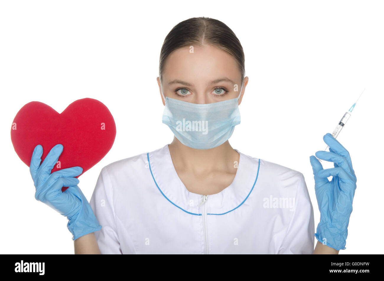 Arzt in Maske zeigt ein Herzsymbol und Spritze Stockfoto