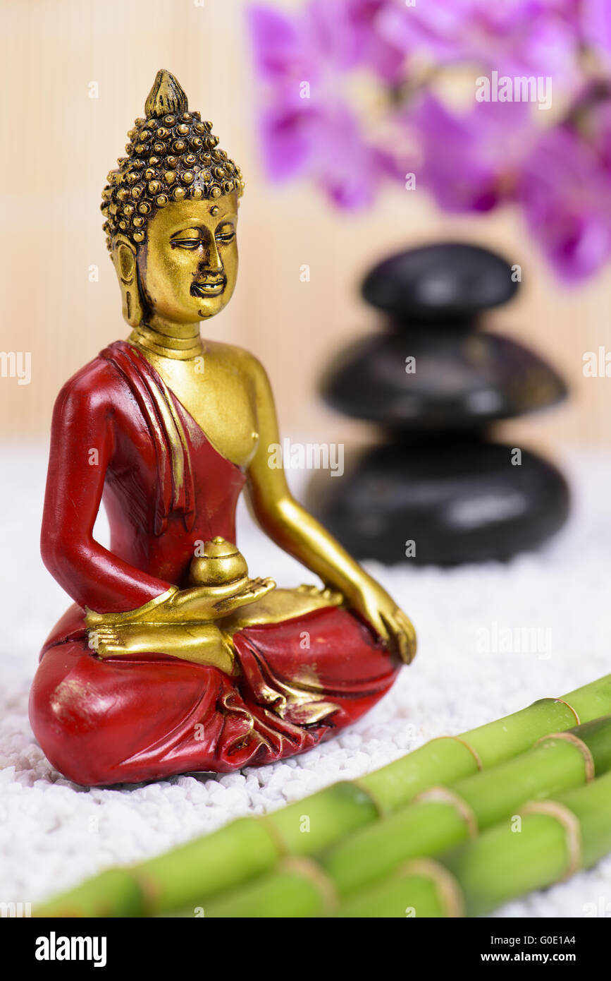 Buddha-Figur im ZEN-Garten mit gestapelten Steinen Stockfoto