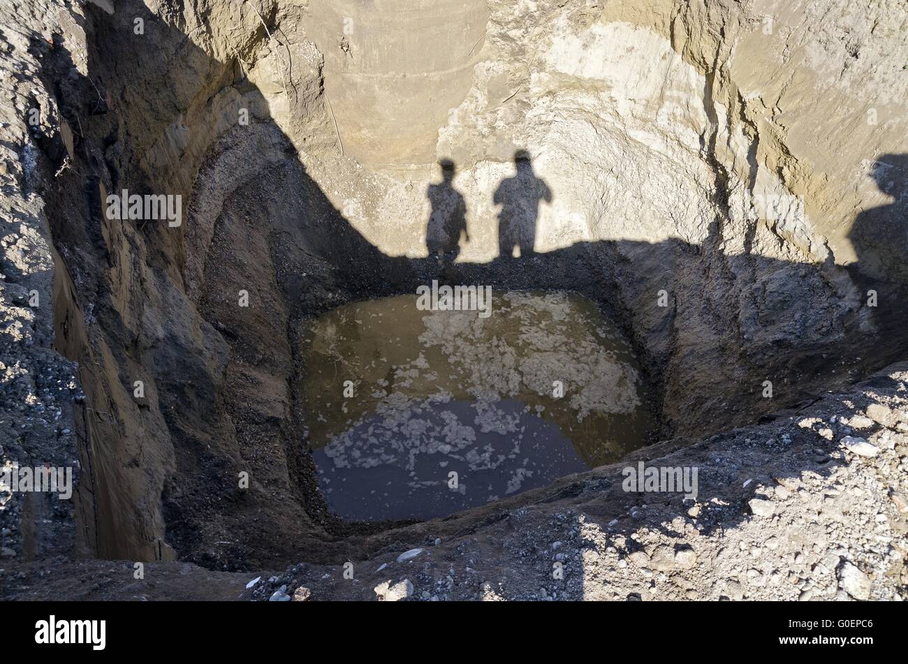 Schatten von zwei Personen am Rande einer Grabung Stockfoto