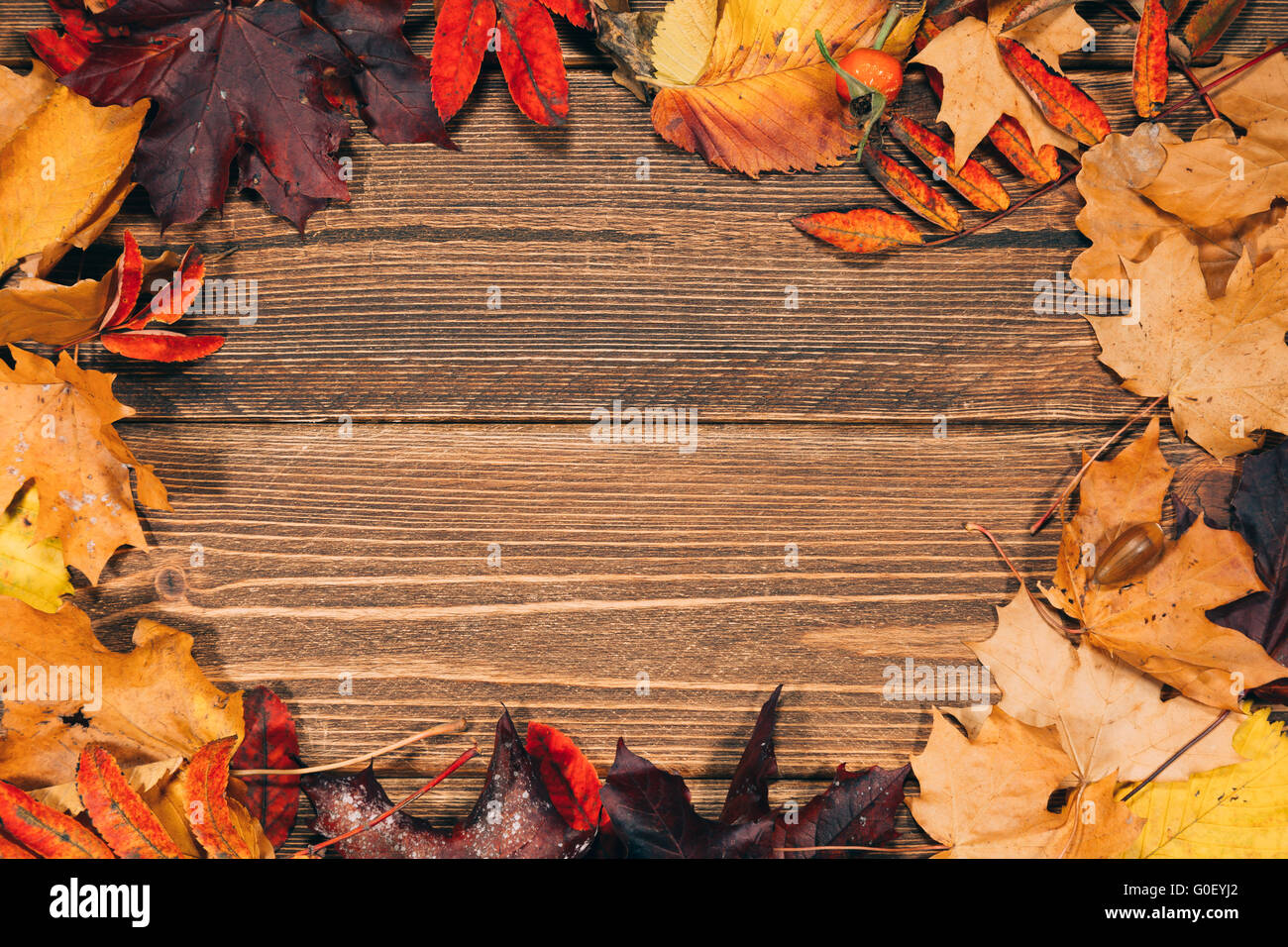 Hintergrund mit Holztisch und herbstliche Blätter Stockfoto